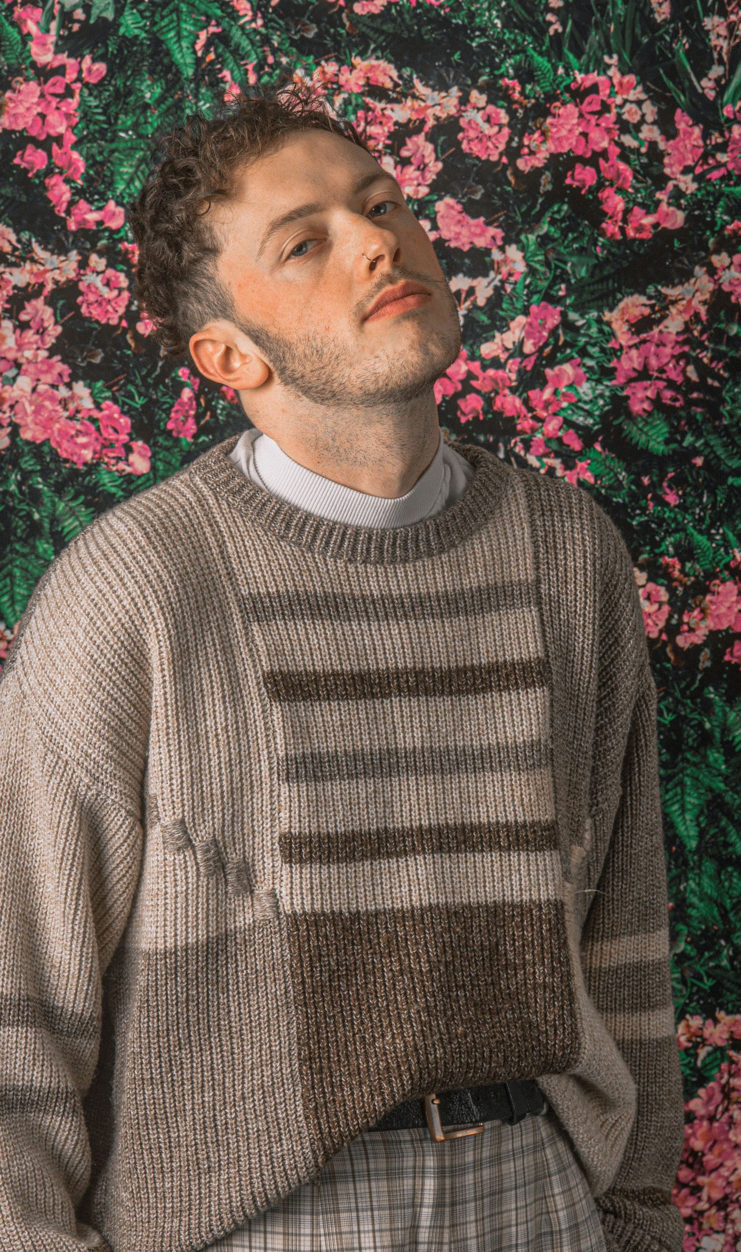 Artistic fashion photos featuring grey striped sweater against pink floral background.