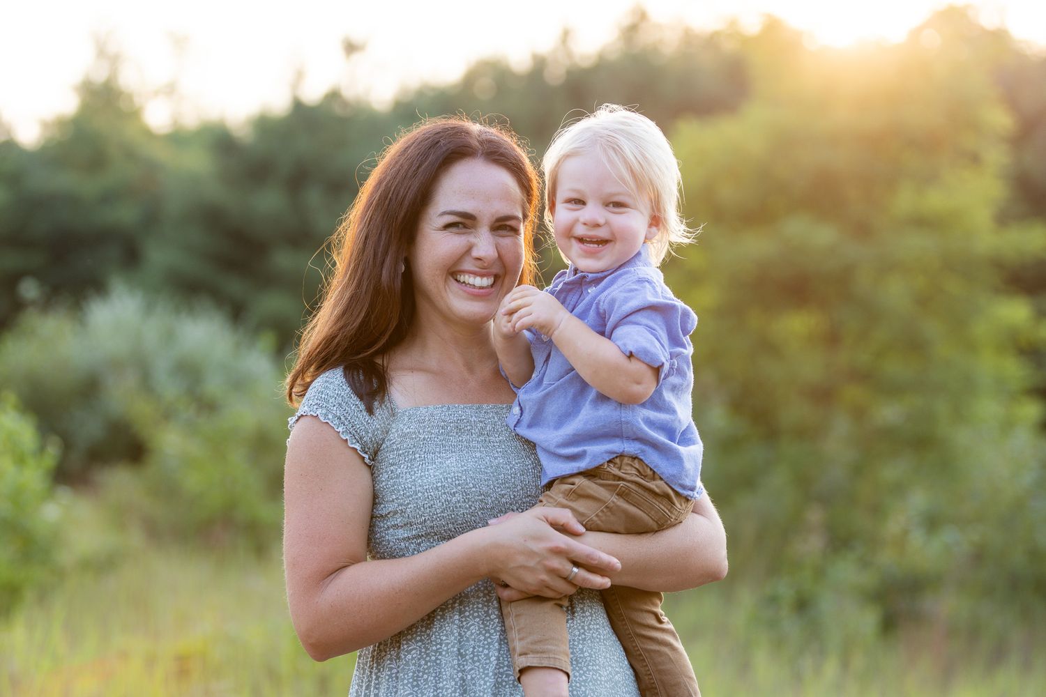 Sweet candid moments between a parent and young child outdoors at sunset.