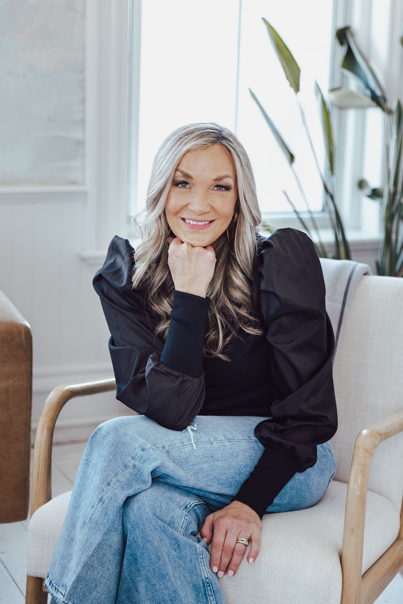 Lifestyle portrait session in modern bright room with wooden furniture.