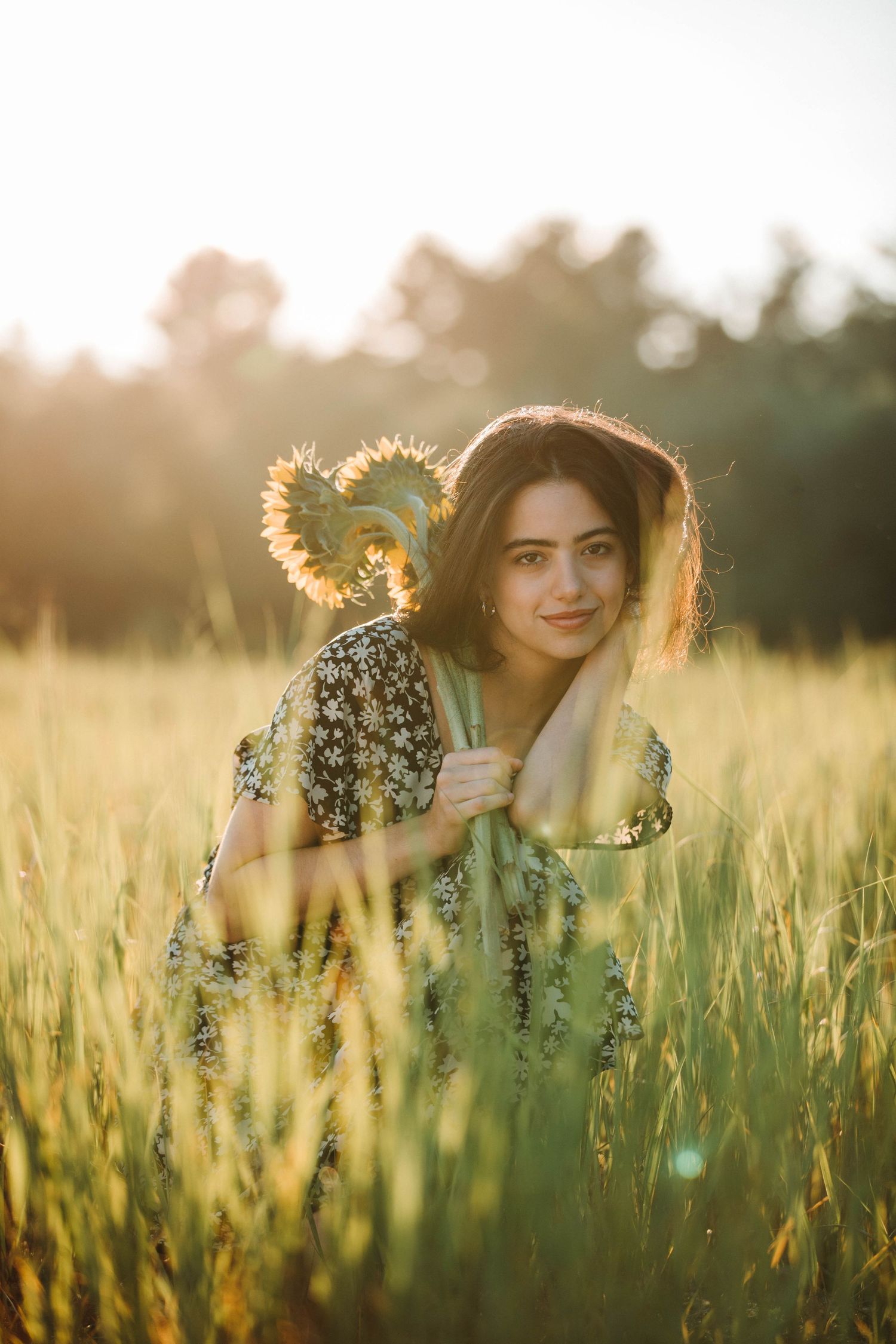 Dreamy golden hour photoshoot in a tall grass field with sunlit backlighting.