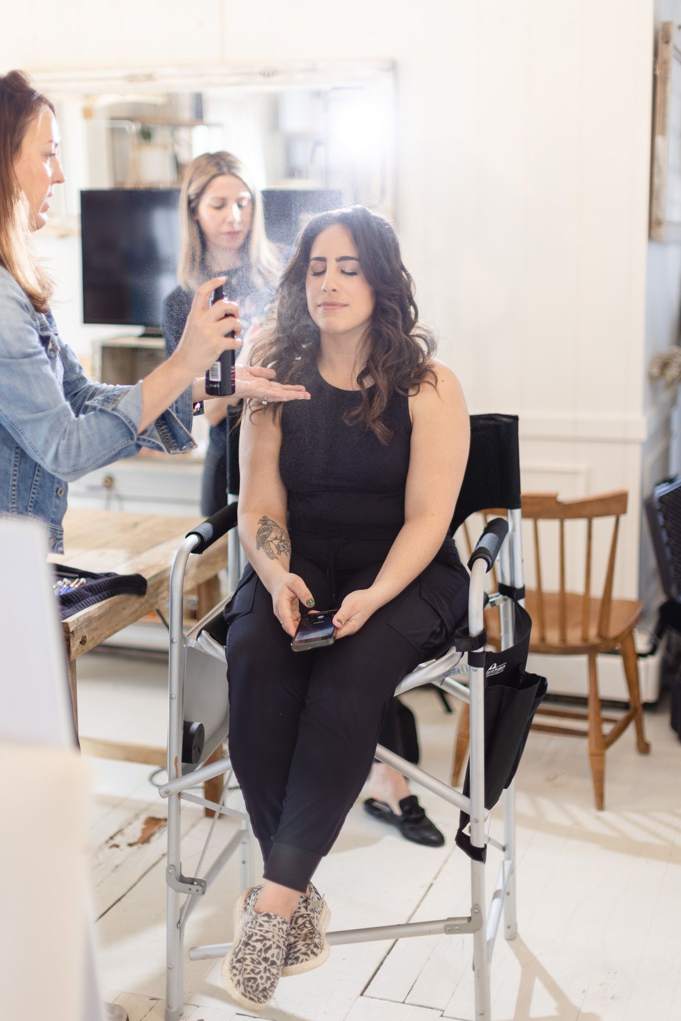 Professional styling session in progress with beauty equipment and casual attire.