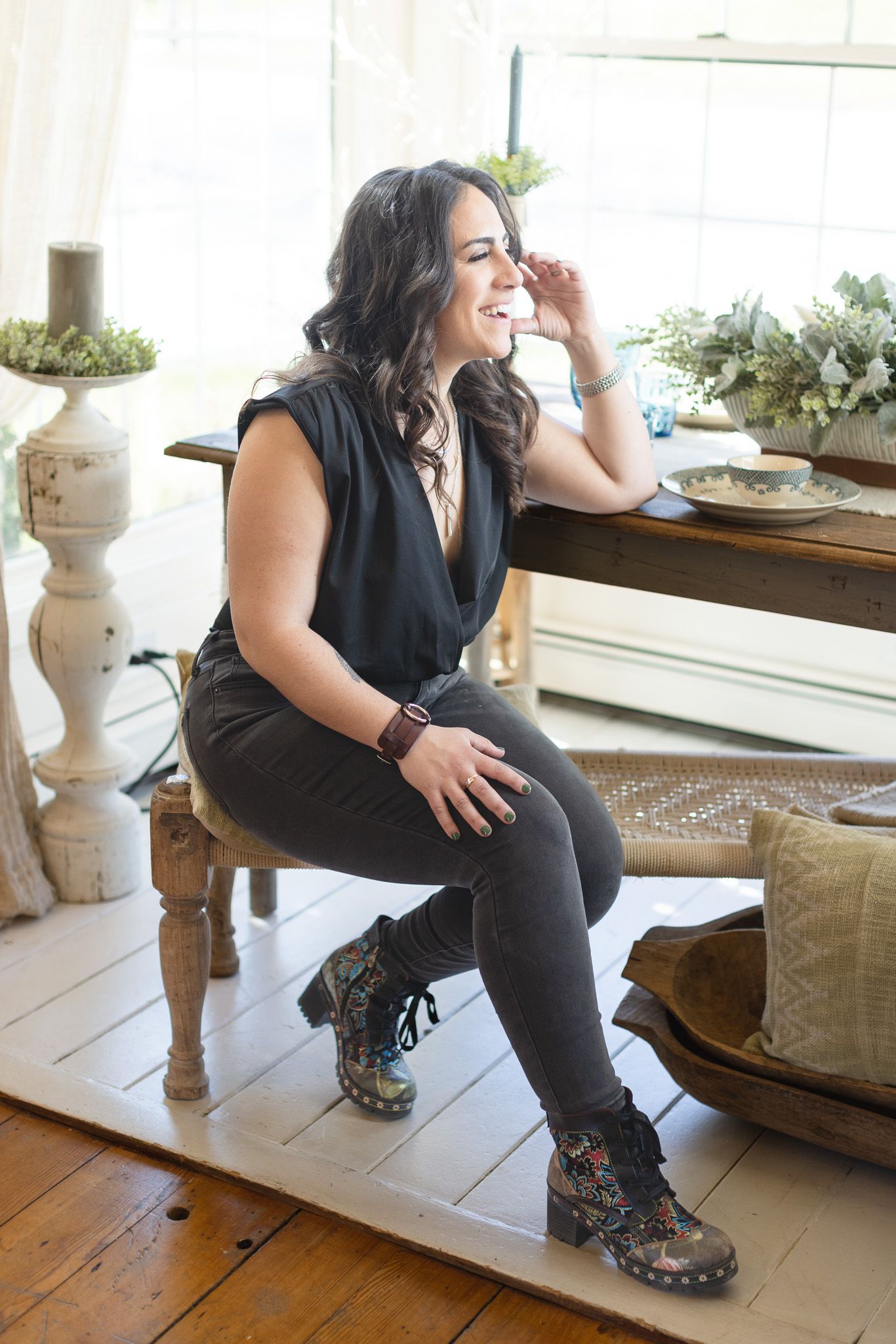 Fashion photography session on wooden floor with decorative furniture and natural lighting.