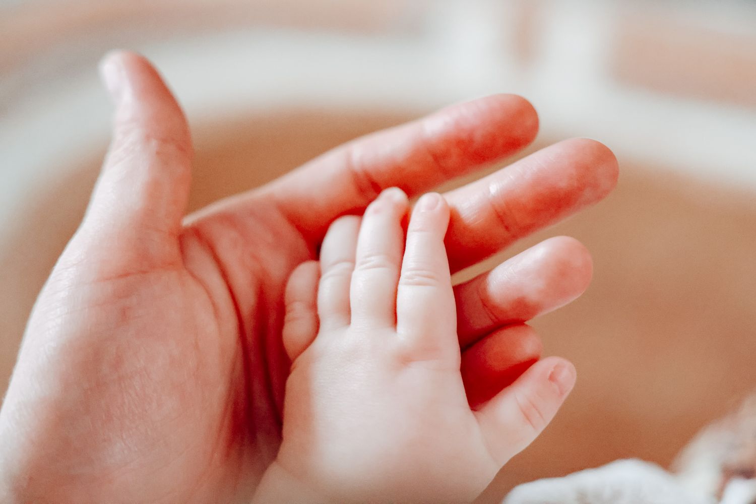 Close-up of baby's small hand reaching out.