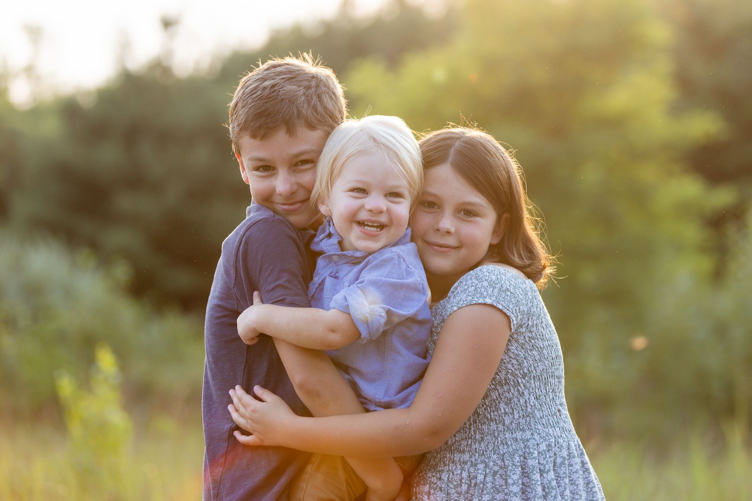 Happy family embraces while enjoying outdoor photo session in natural setting.