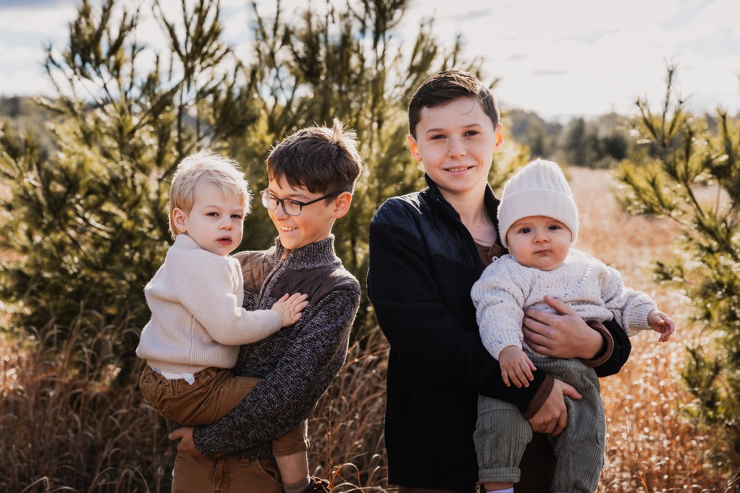 Group portrait in a pine forest during golden hour.