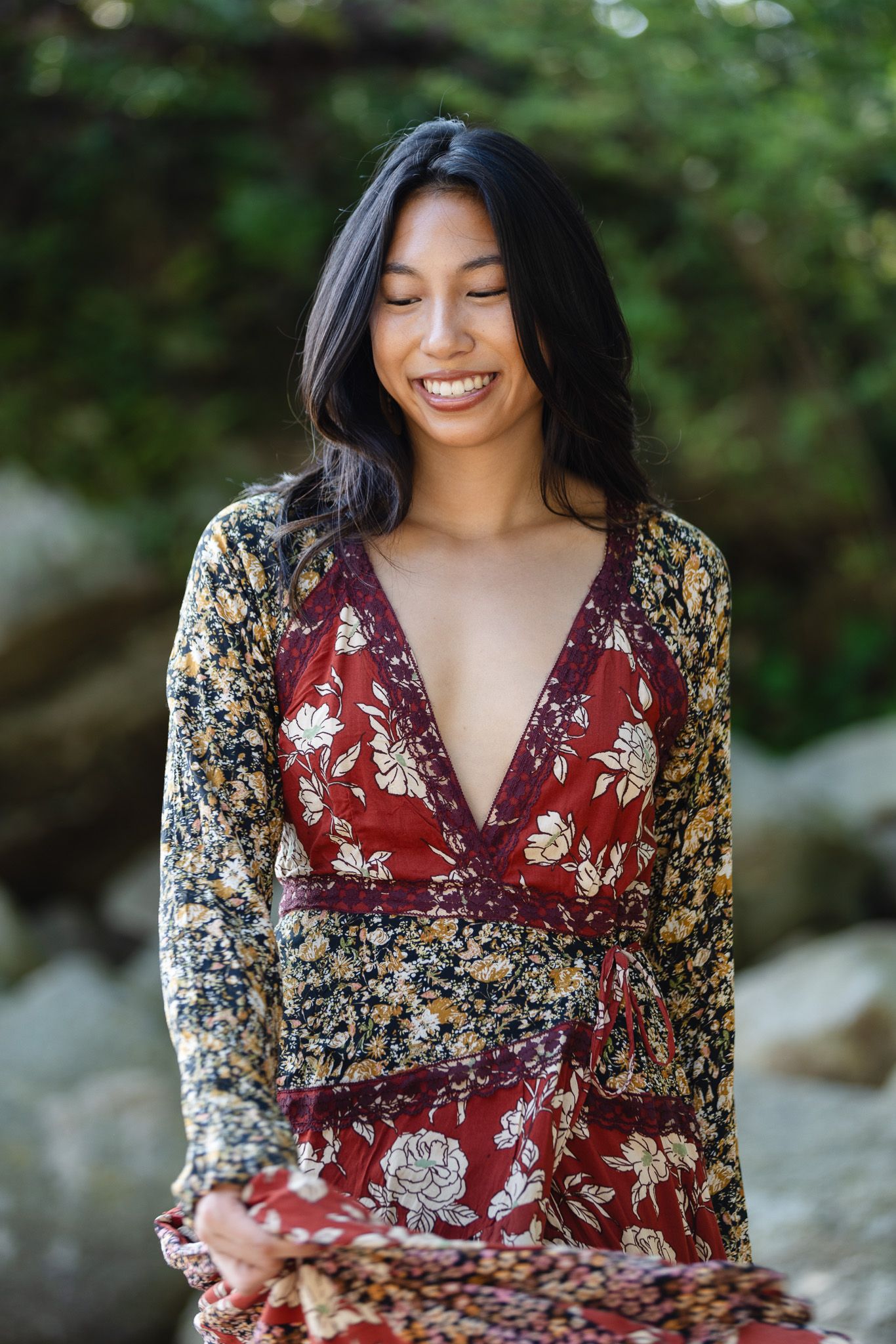 A floral wrap dress photographed outdoors against natural rock formations.