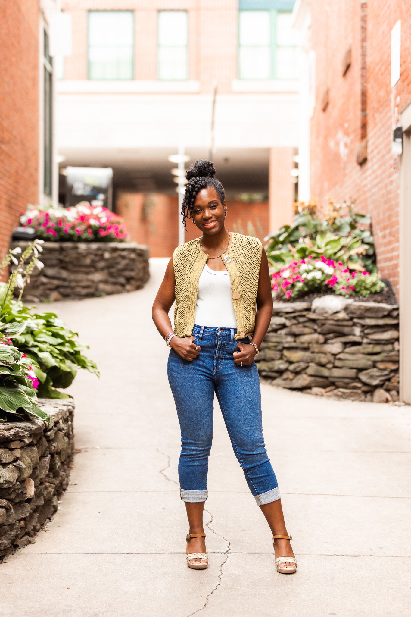 Casual urban portraits showing someone in rolled denim and a yellow vest near stone walls.