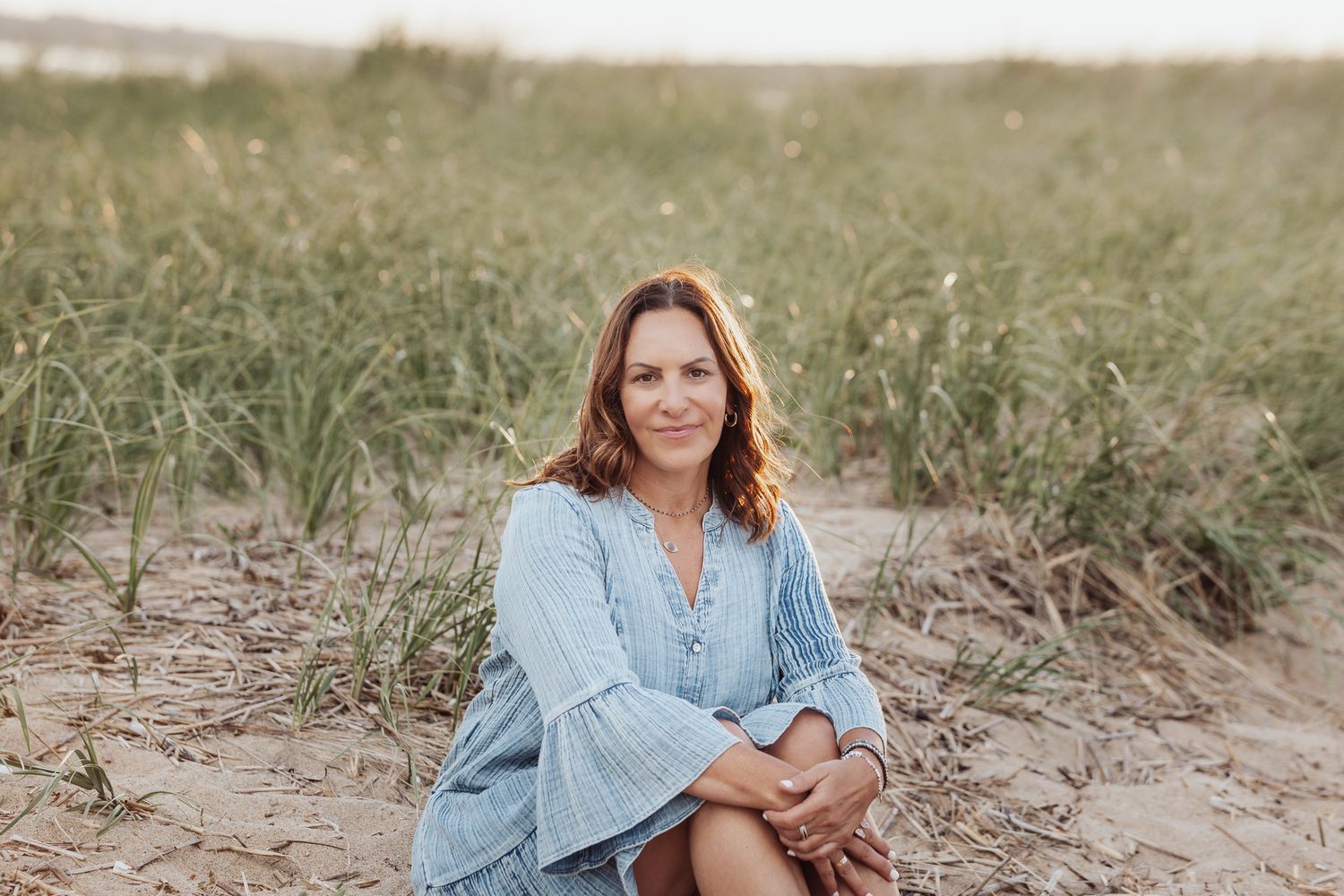 Outdoor beach scene with soft natural lighting and coastal vegetation.
