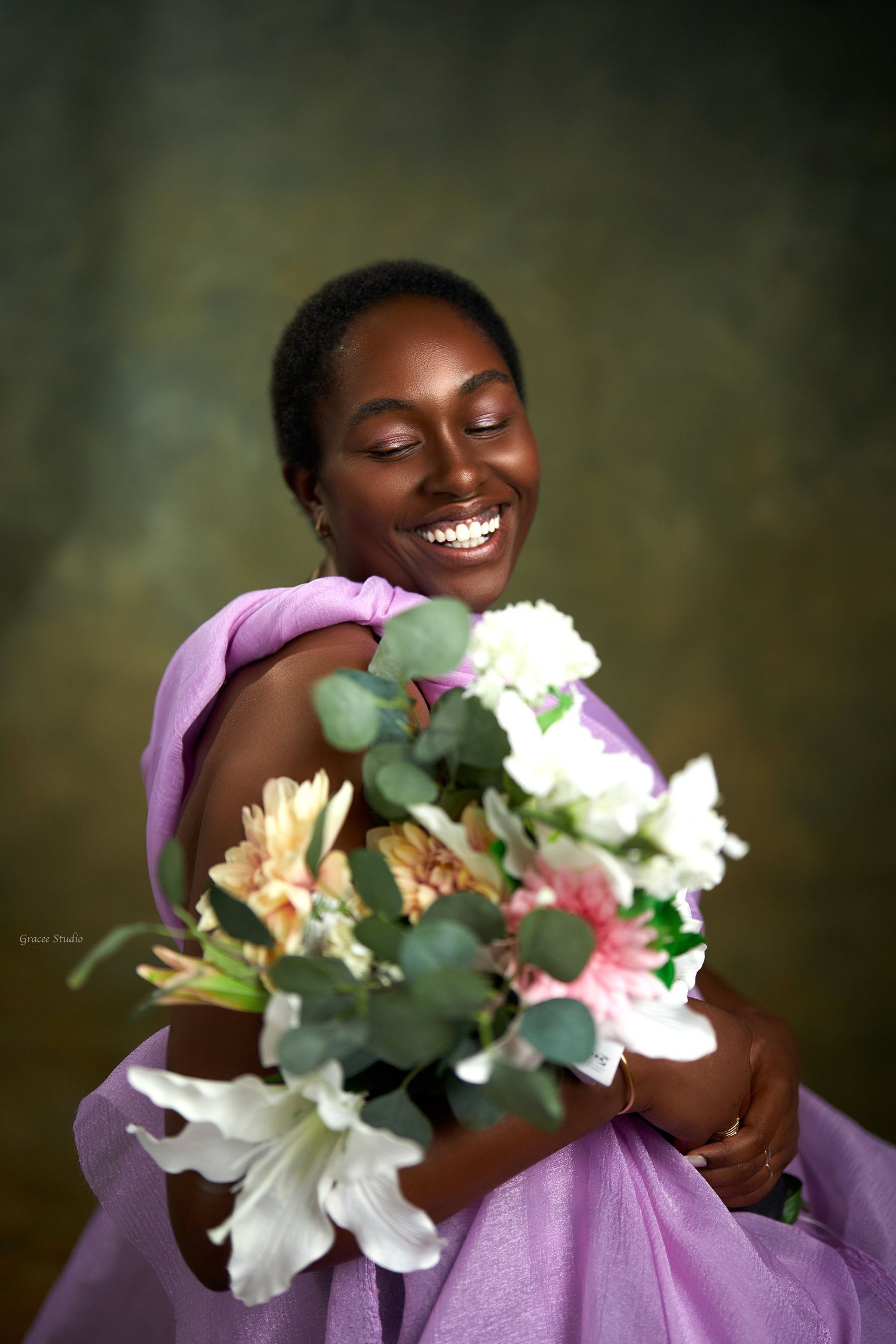 A joyful moment captured with white flowers and a purple sweater against a dark background.