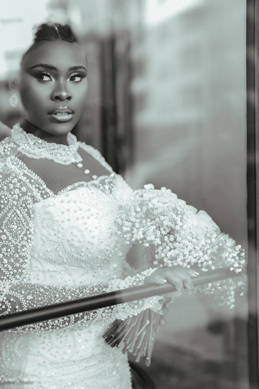 A stunning black and white portrait showcasing an elegant bride in her wedding dress with intricate lace and beaded details.