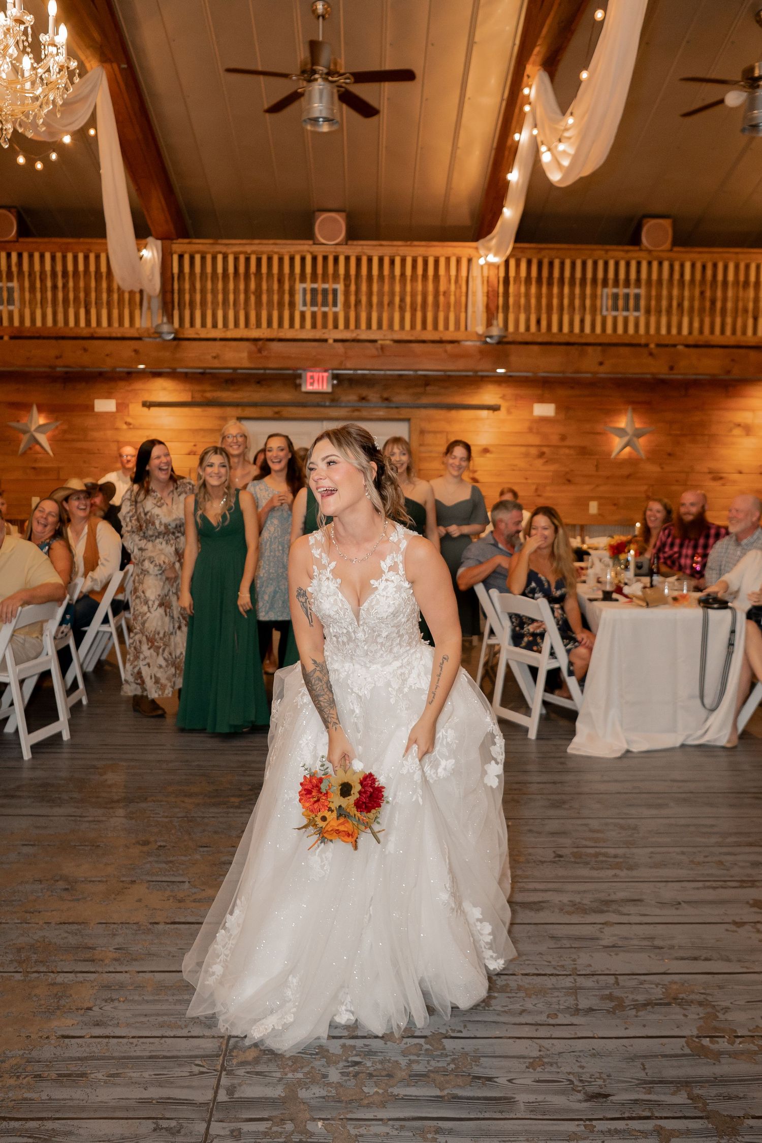 Wedding reception in a rustic wooden hall with string lights and decorated tables.