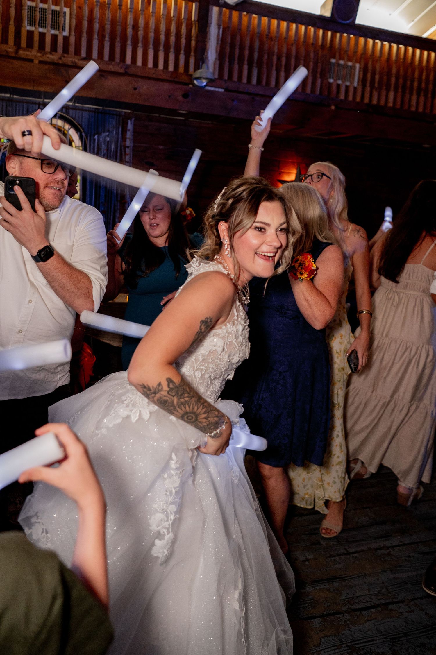 Wedding celebration with dancing and festivities in a wooden reception hall.