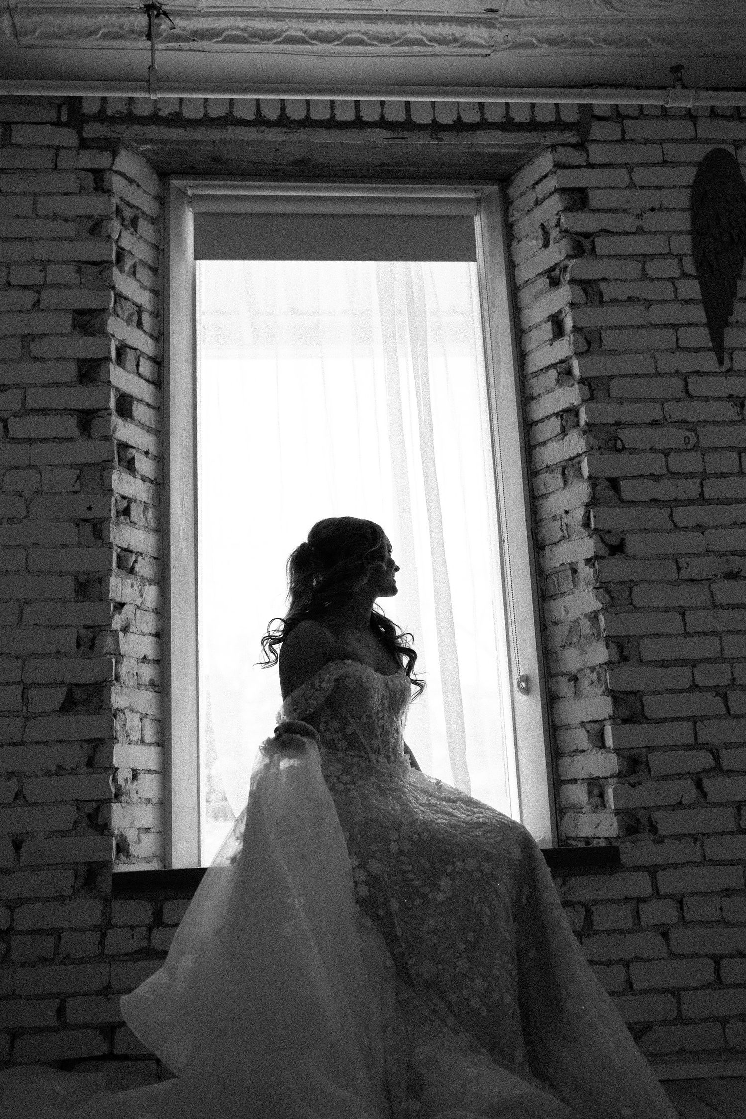 Dramatic black and white silhouette through brick window frame.