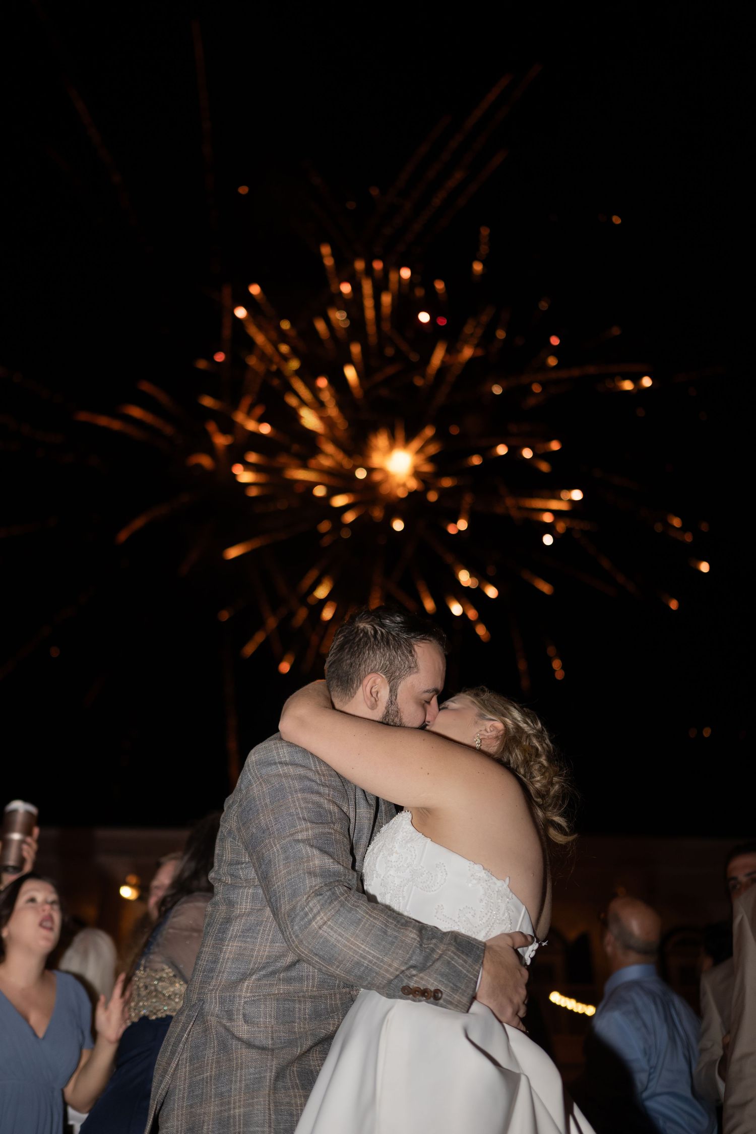 Wedding celebration at night with fireworks lighting up the dark sky.