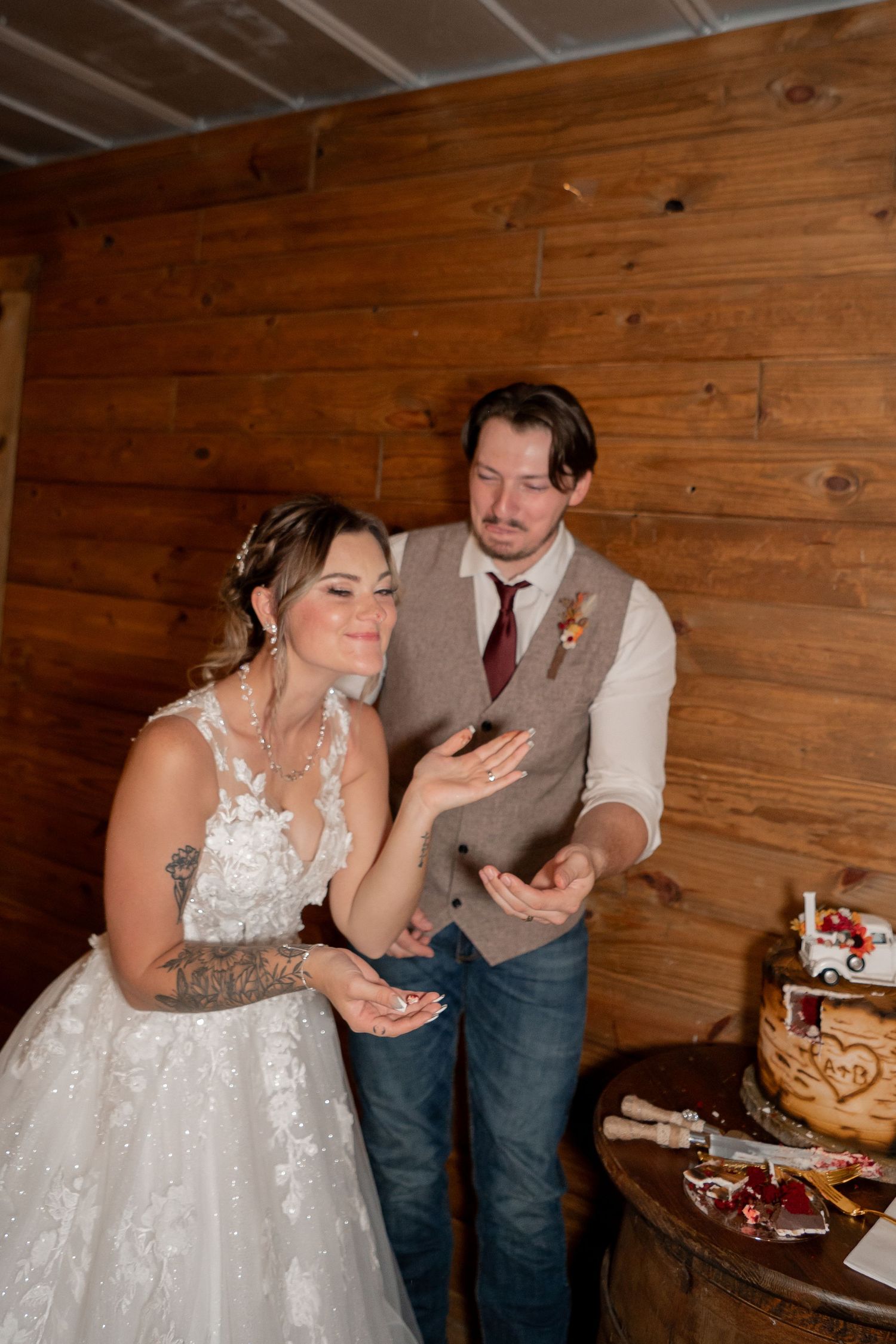 Wedding reception scene with cake tasting in a rustic wooden venue.