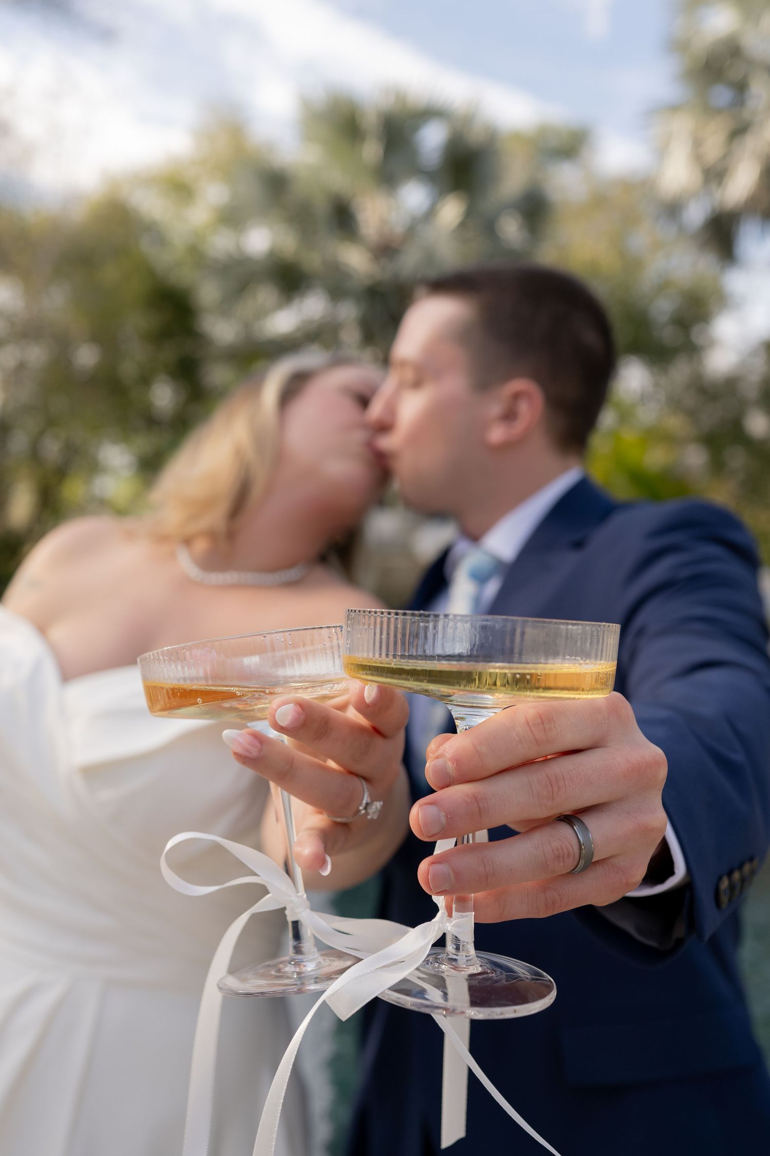 Black and white wedding photos showing couple toasting with champagne glasses.