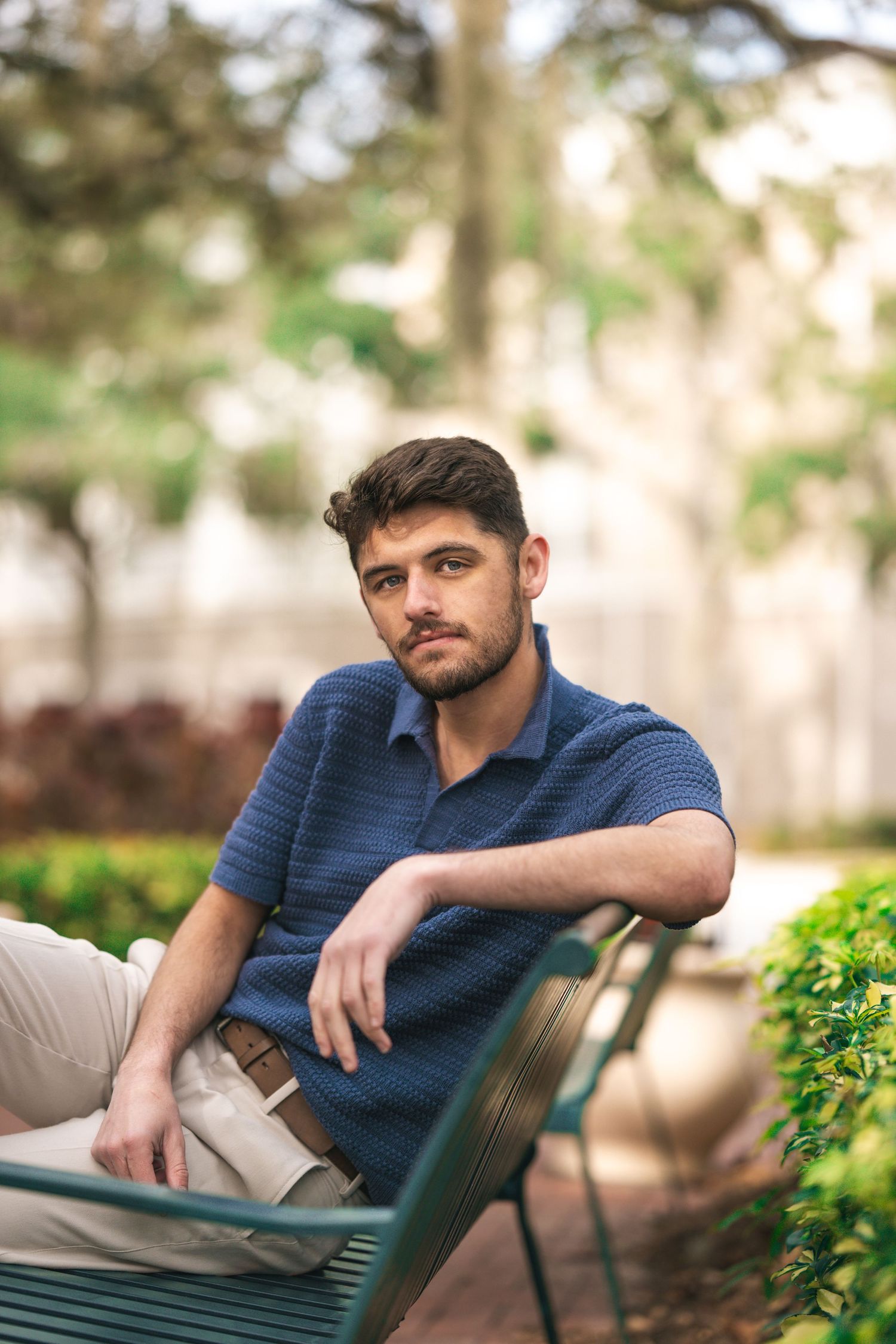 Casual outdoor portraits showing person seated on green bench in park setting.
