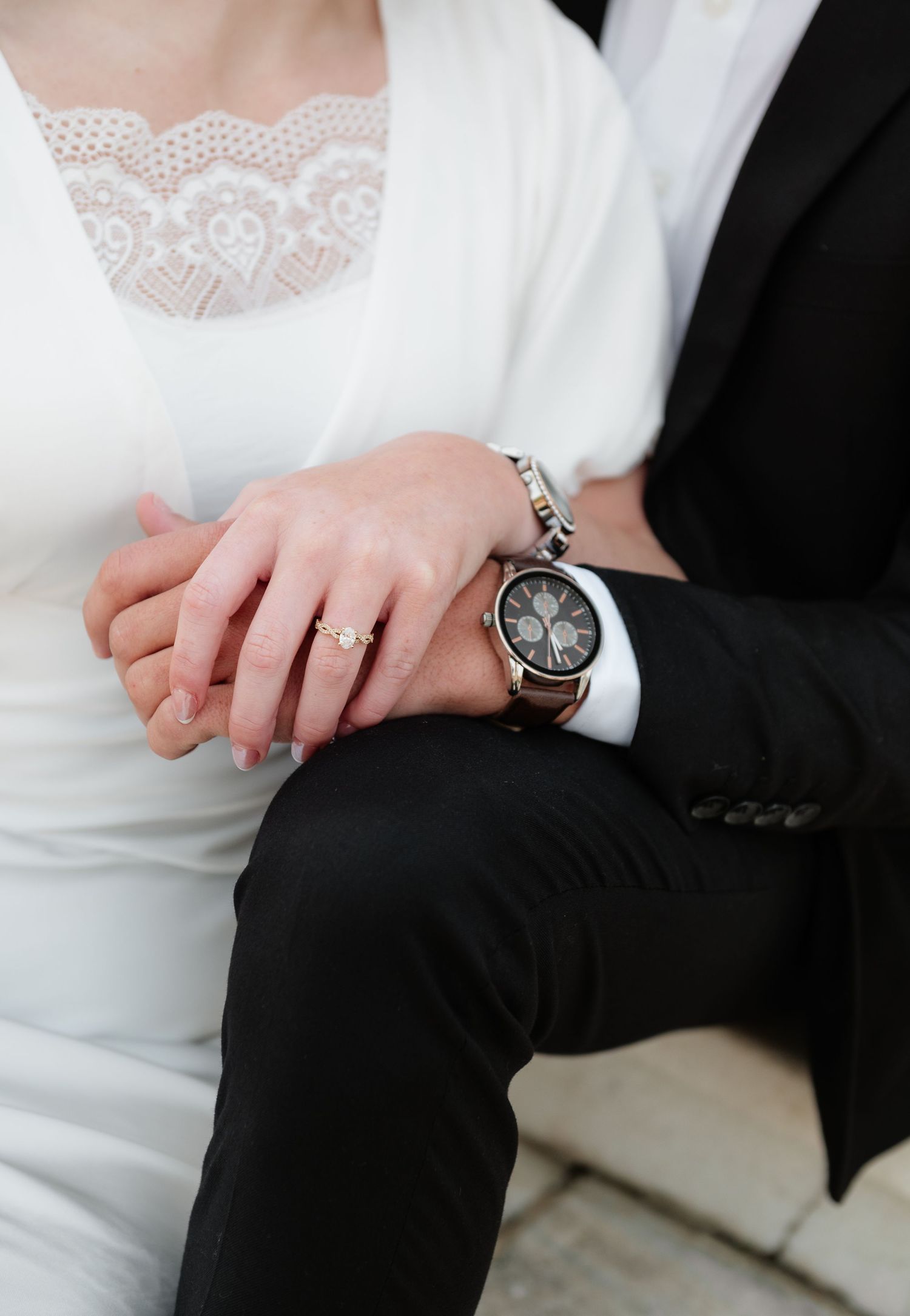 Close-up detail of wedding attire showing lace dress fabric and formal suit.