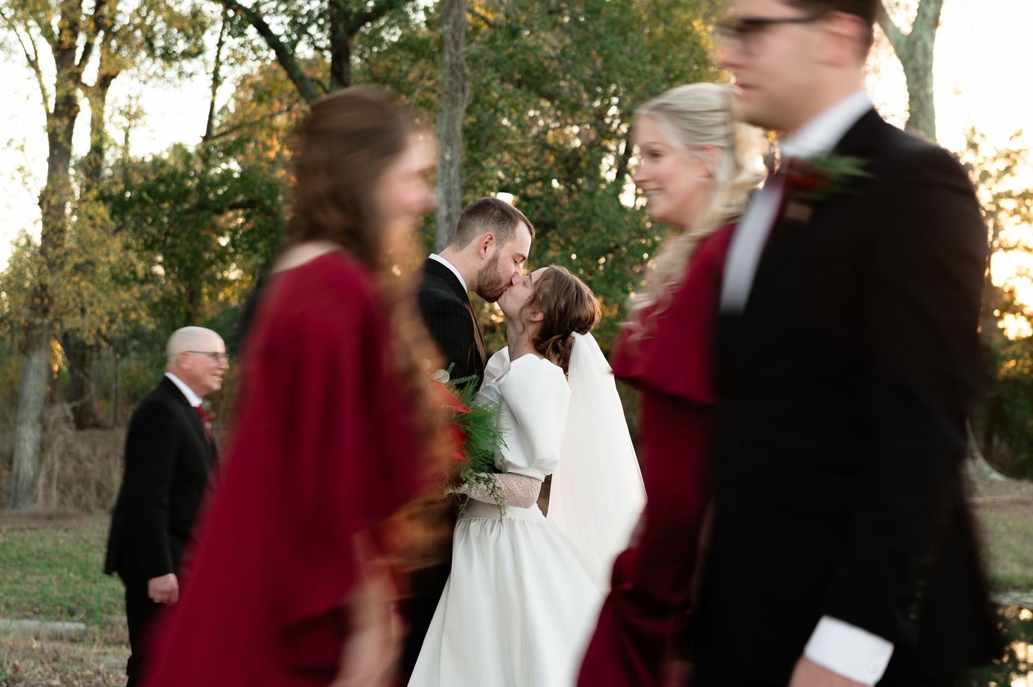 Wedding party gathered outdoors with blurred motion creating a dreamy effect.