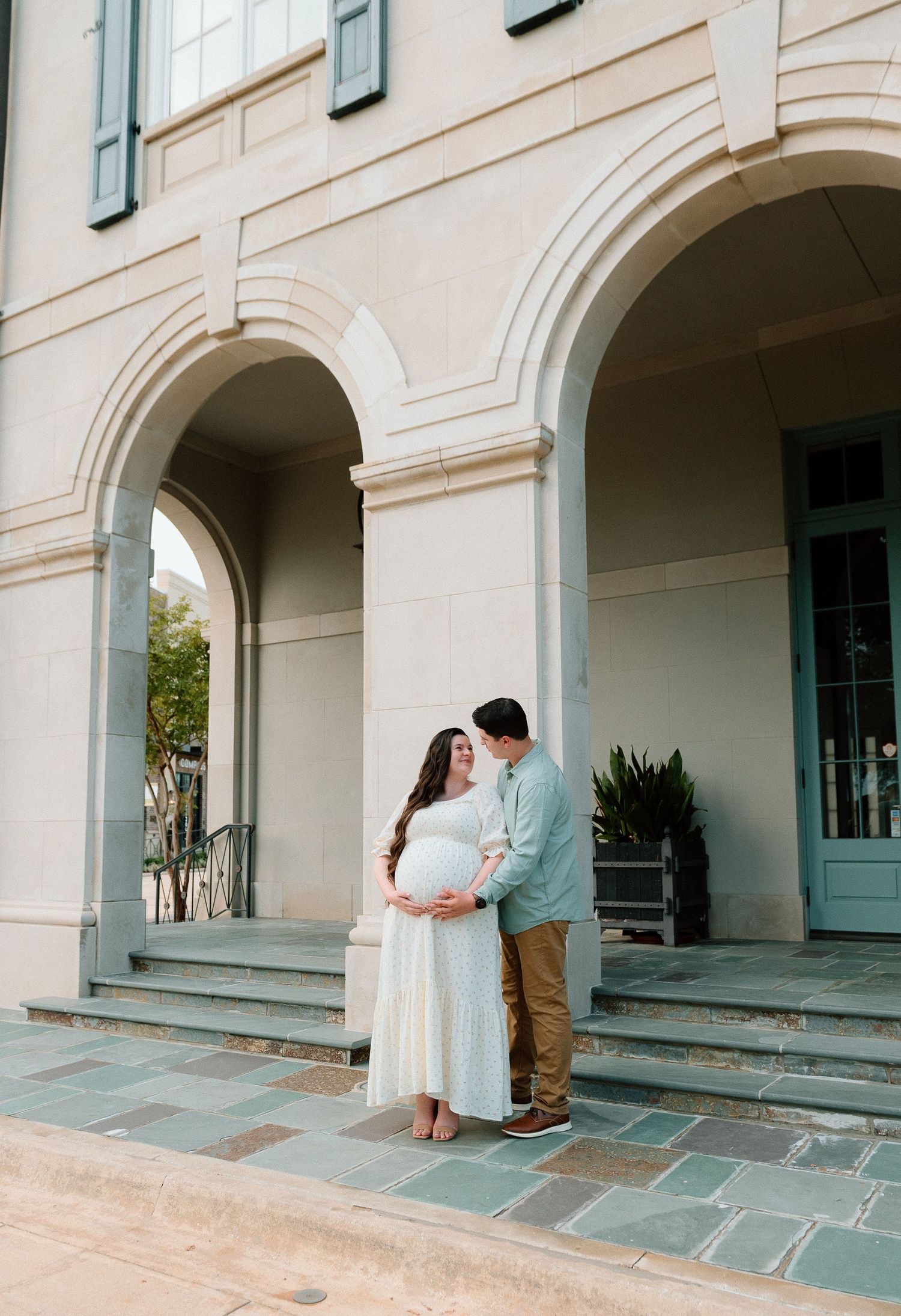 Romantic sequence of a couple on elegant stone porch with arched architecture.