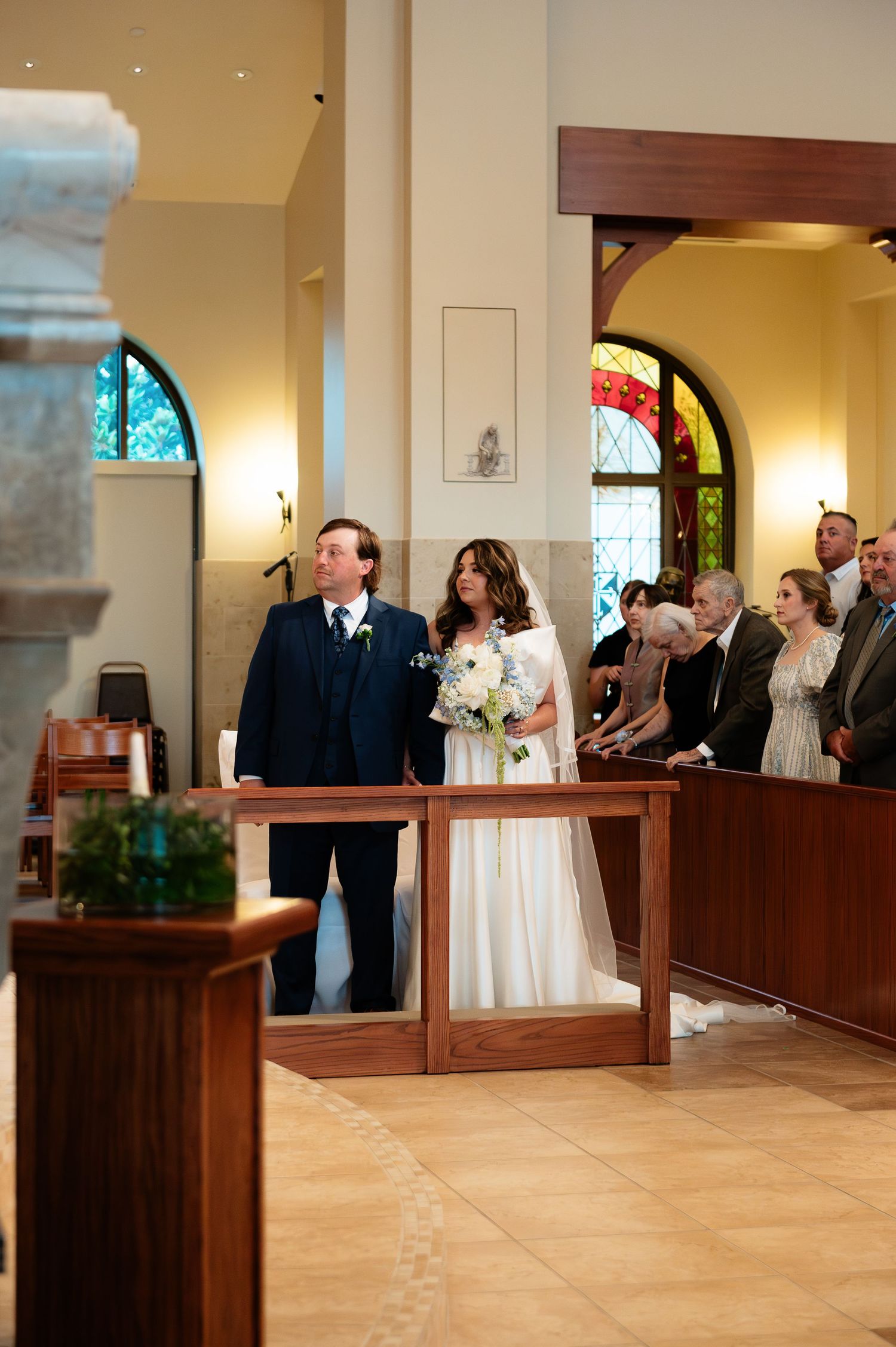 Bride and groom walking down the aisle in an elegant church during their wedding ceremony.