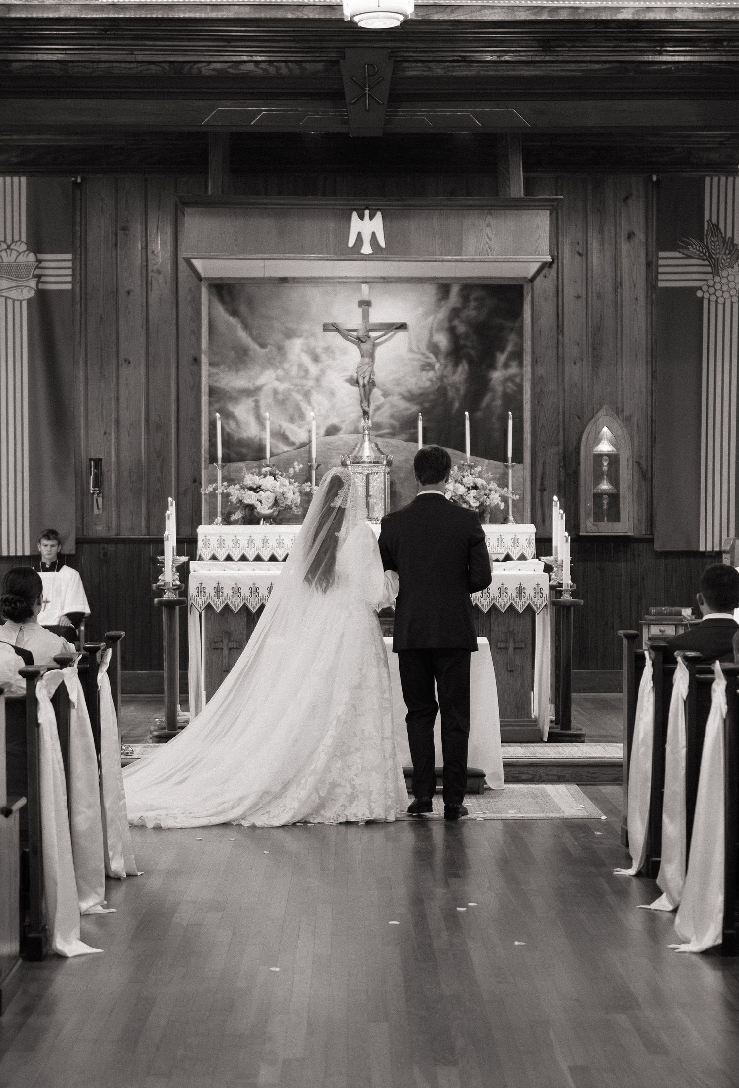 Black and white photo of a bride and groom standing at the altar during a church wedding ceremony.