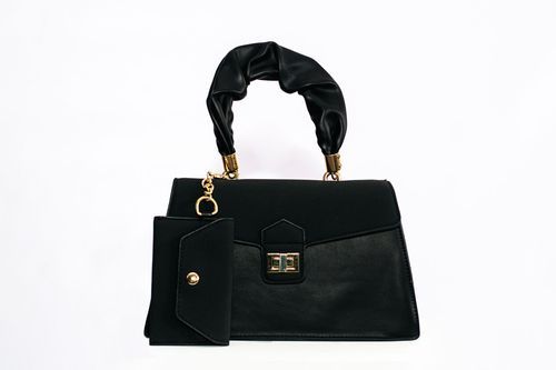black handbag with gold details on white backdrop