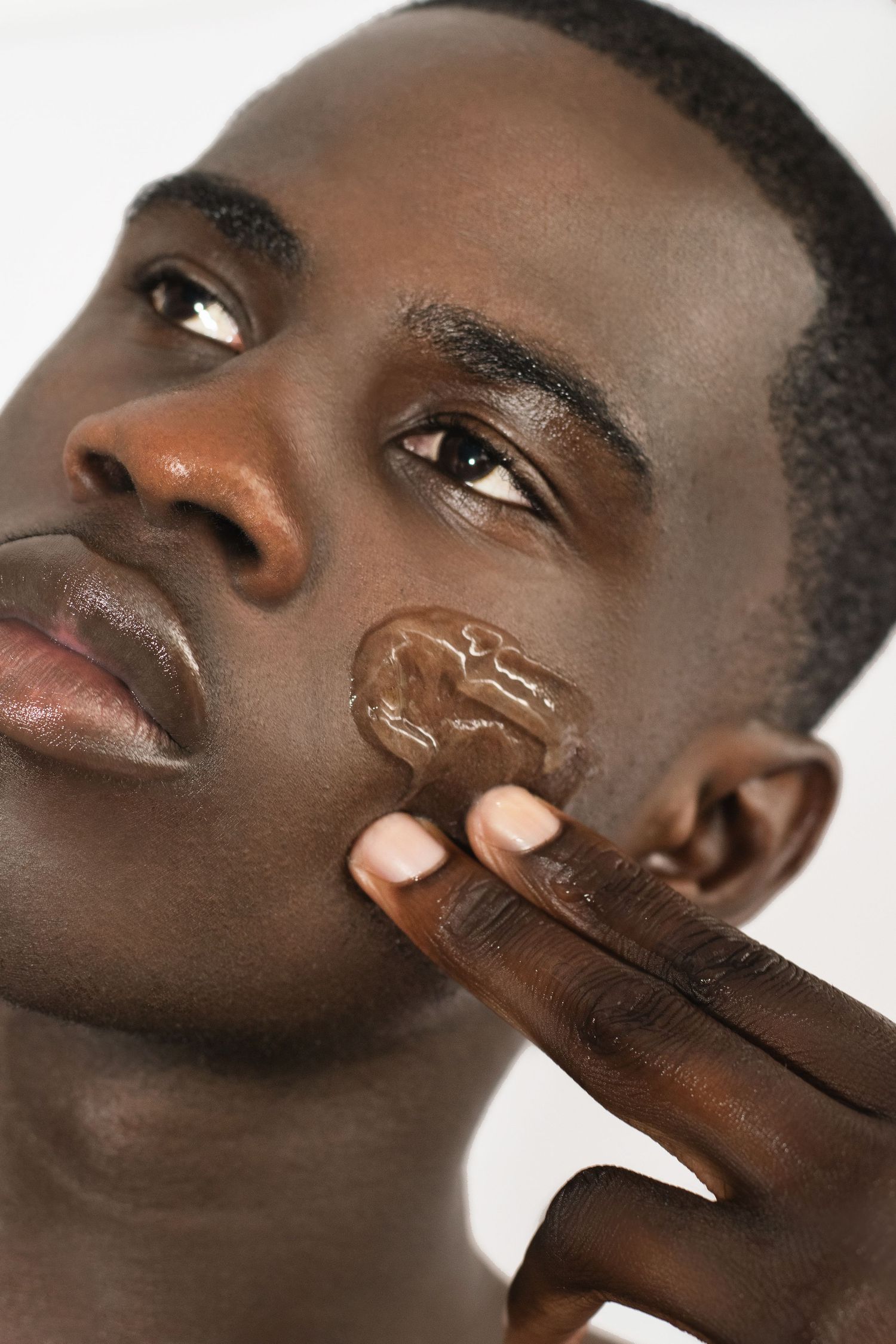 Black man male applying face gel