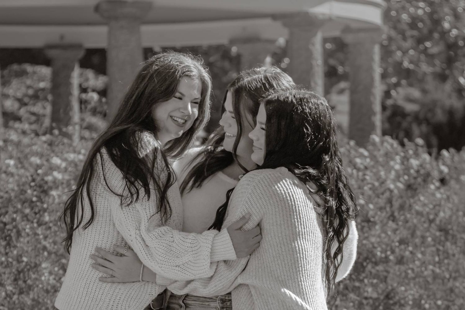 Friends embracing and laughing together in casual outfits.