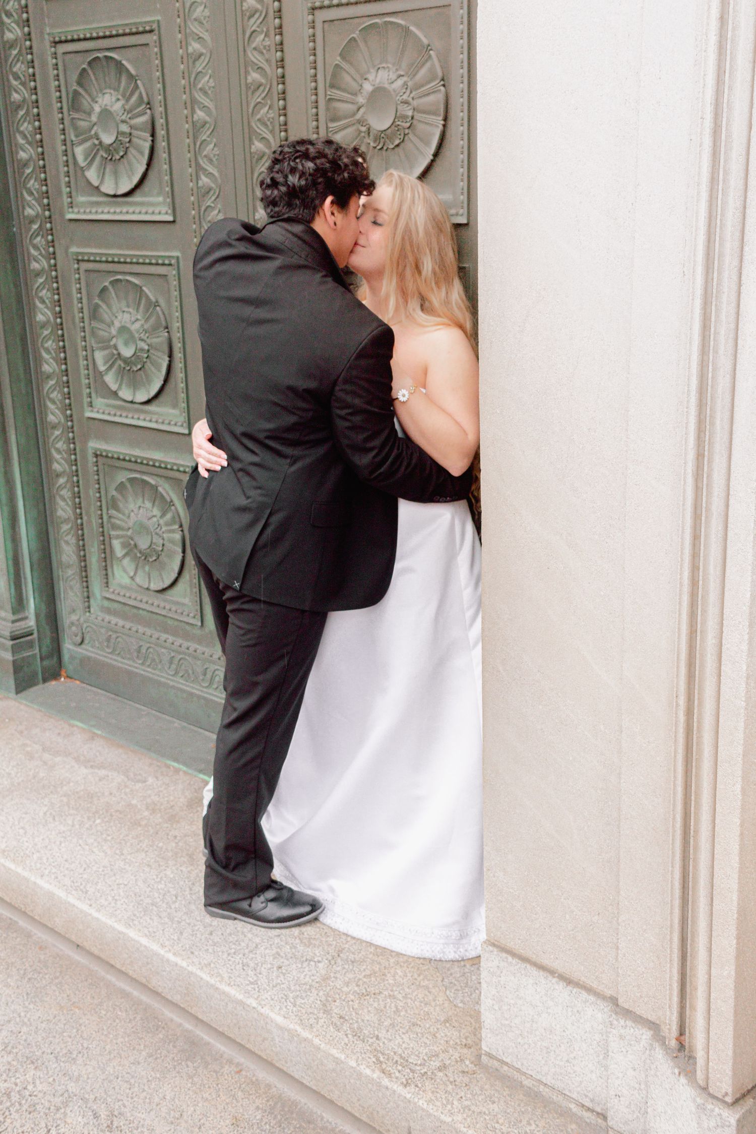 Artistic wedding photos showcase tender moments against a decorative wall.