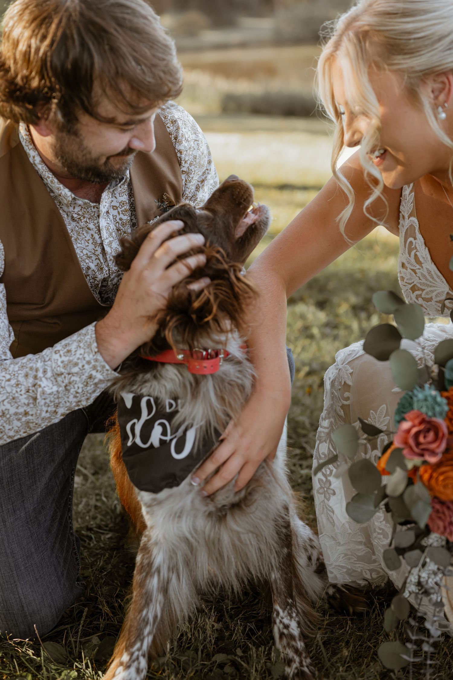 A fluffy dog receives affectionate pets during an outdoor wedding photoshoot.