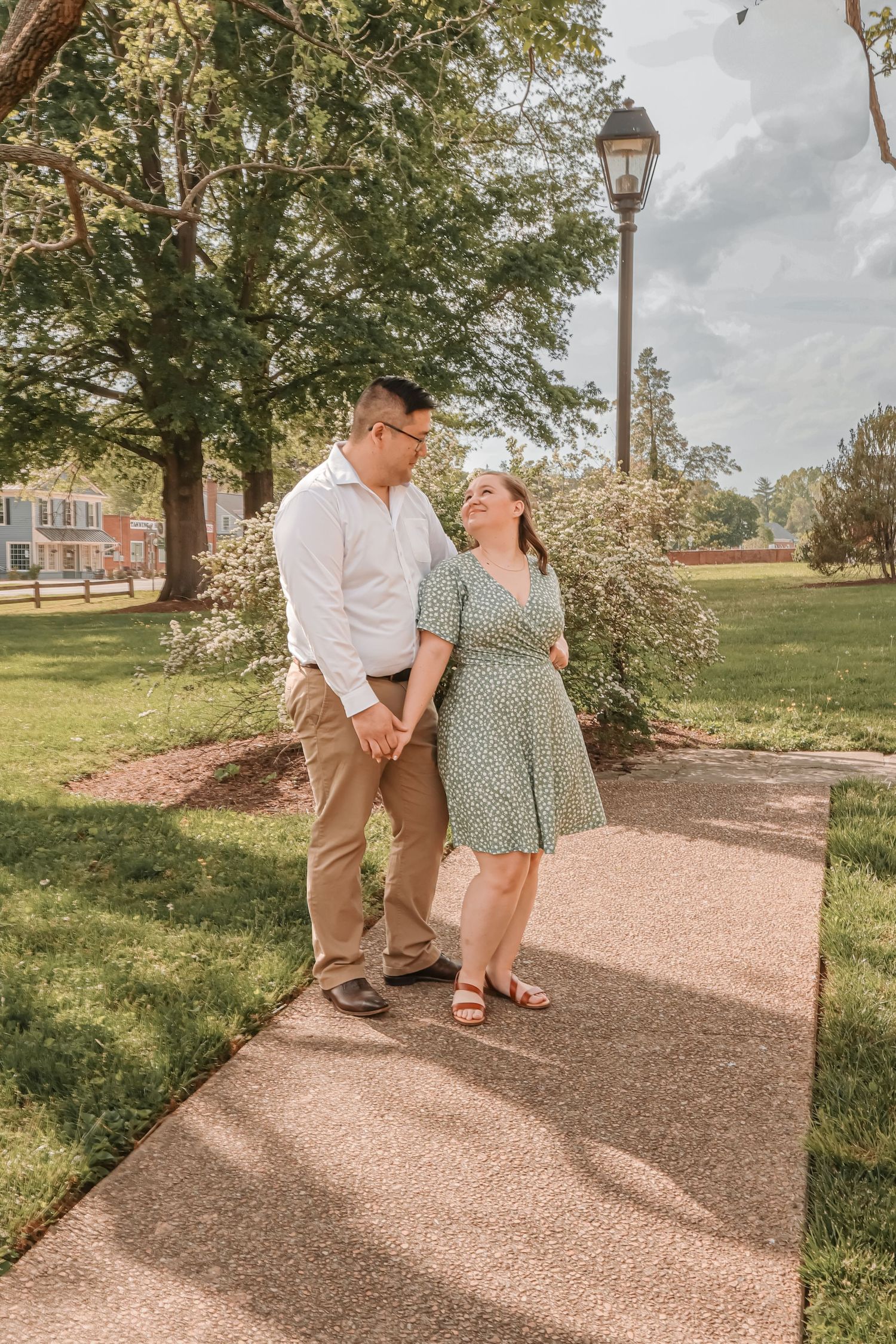 Couple walks together on a scenic pathway through a park on a sunny afternoon.