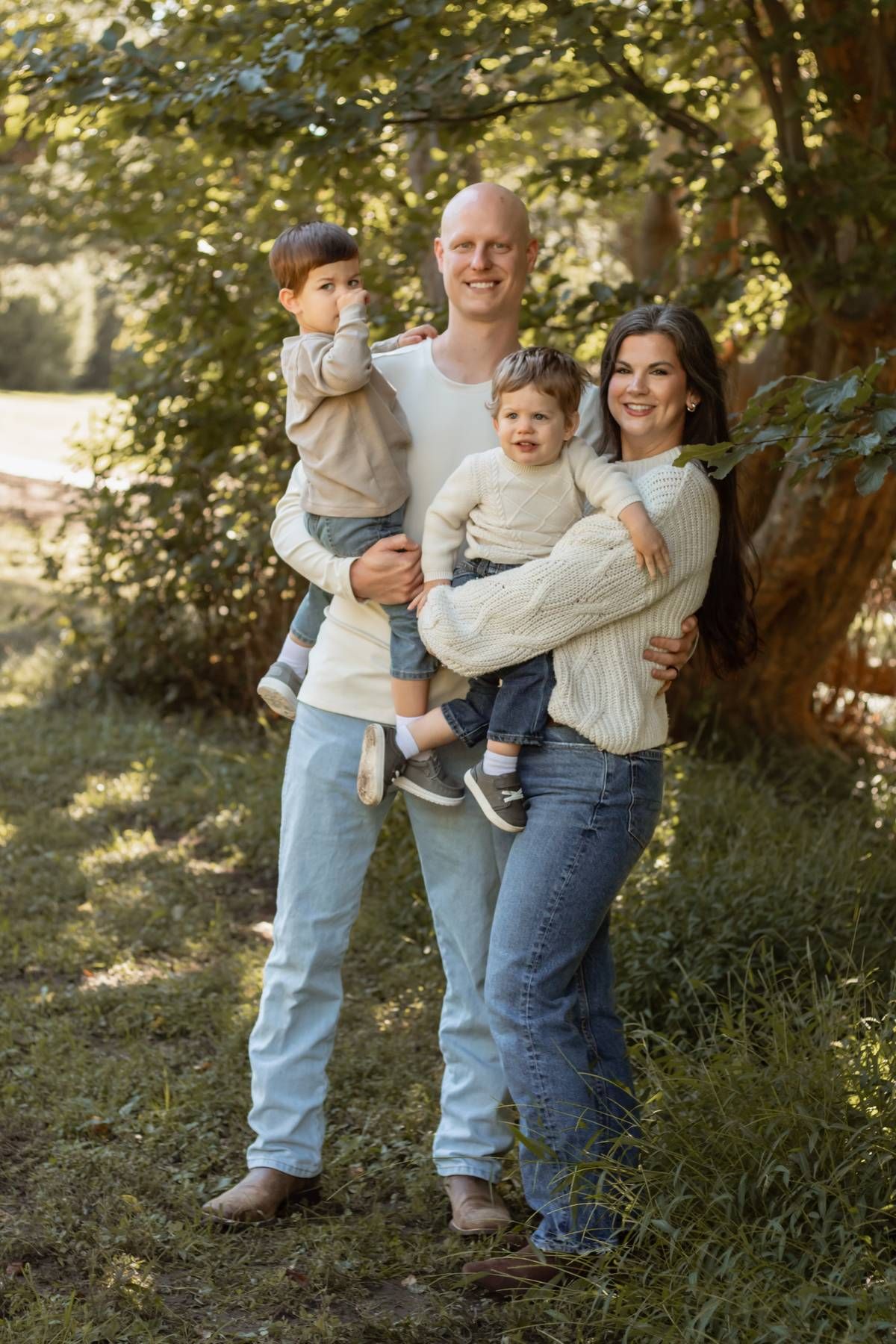 Family portrait series in a wooded setting wearing coordinated casual clothing.