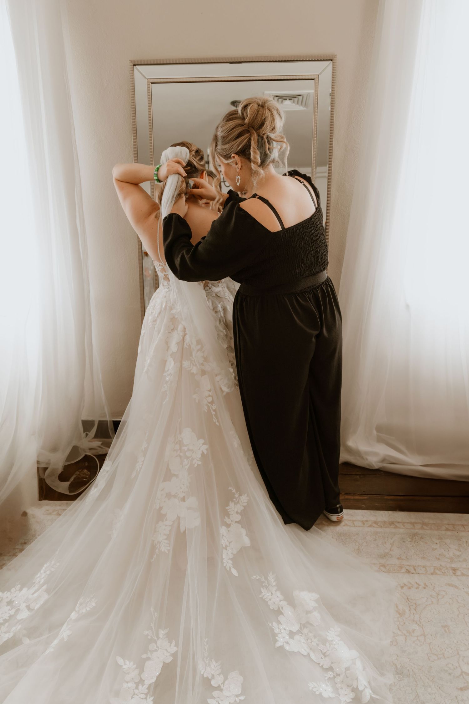 Wedding dress detail shots showing intricate lace and flowing train against white backdrop.