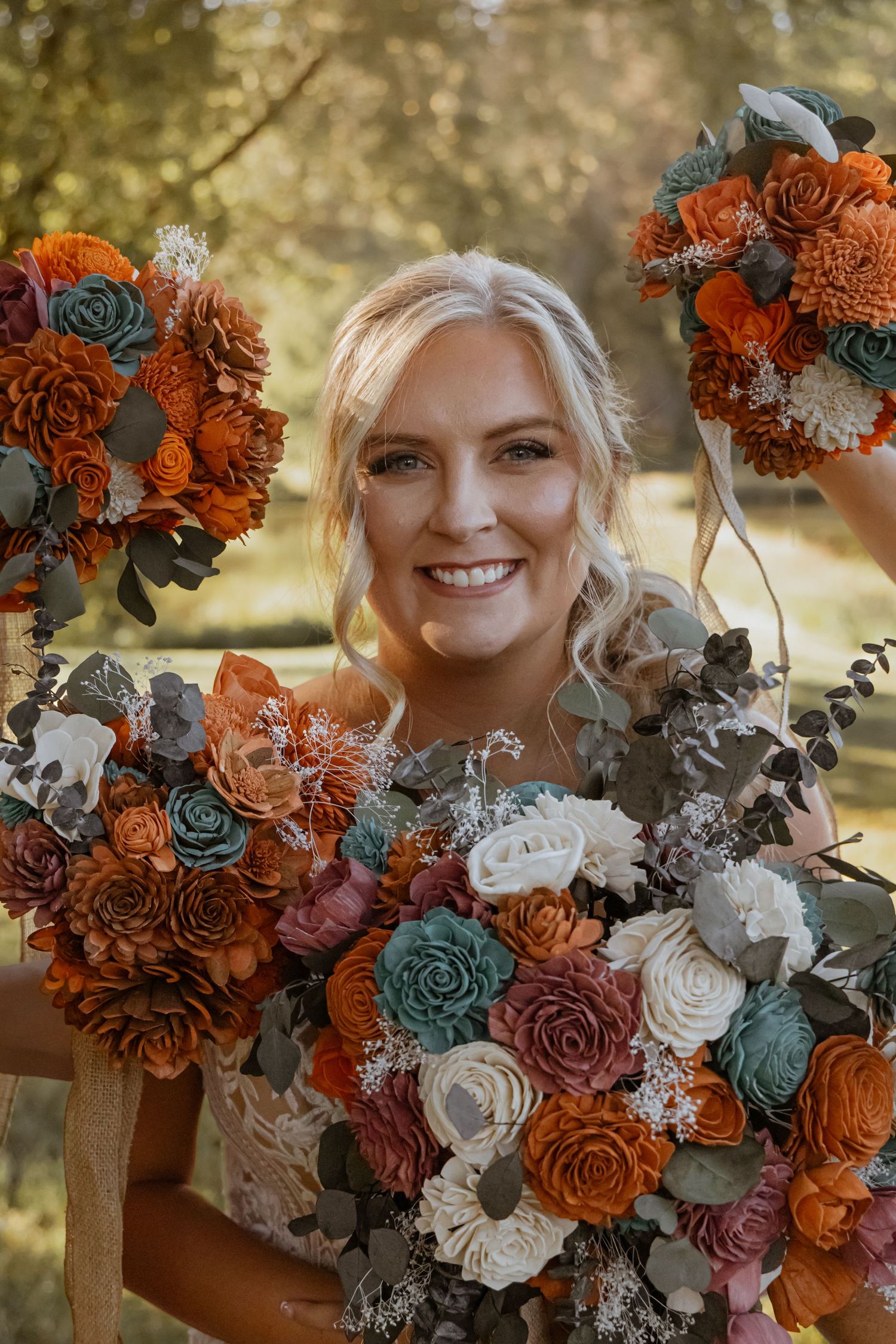 Beautiful autumn wedding bouquet featuring orange roses and teal succulents.
