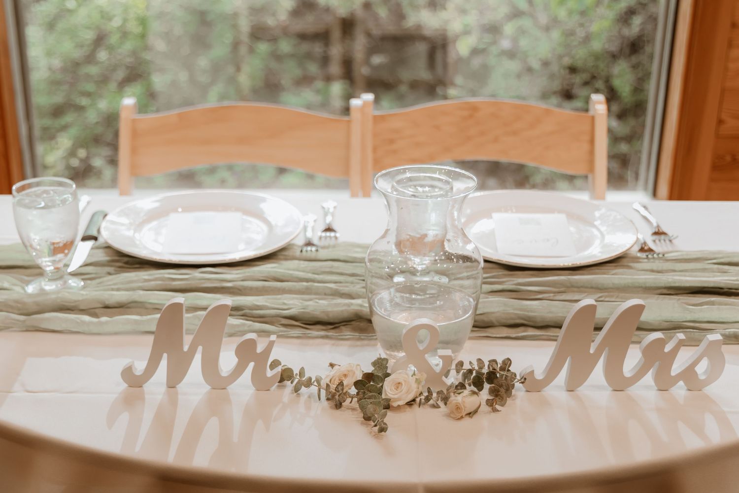 Elegant wedding reception table setting with place settings and Mr and Mrs signage.