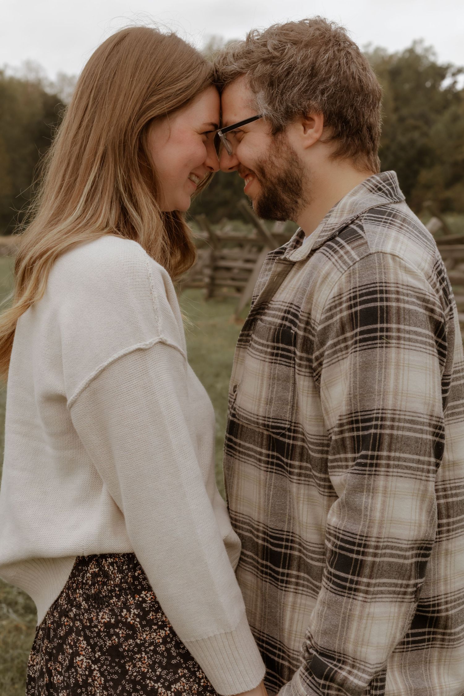 Couple in coordinated outfits sharing a tender moment outdoors.