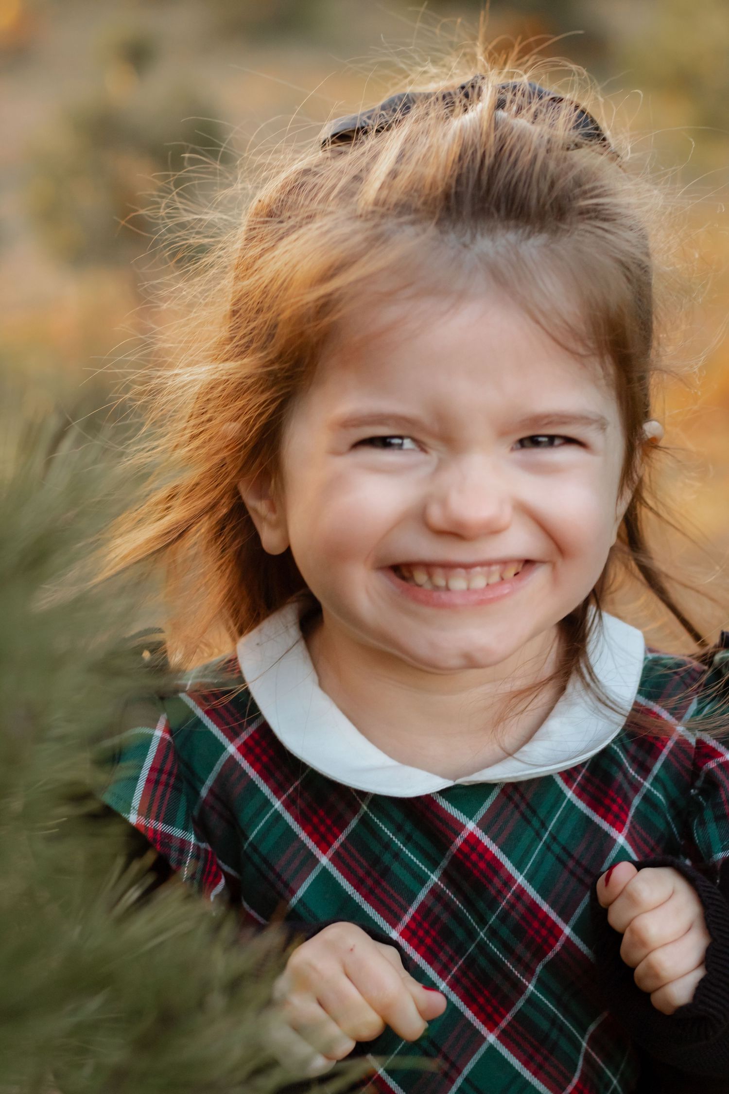 Series of candid expressions in a plaid dress against an autumn background.