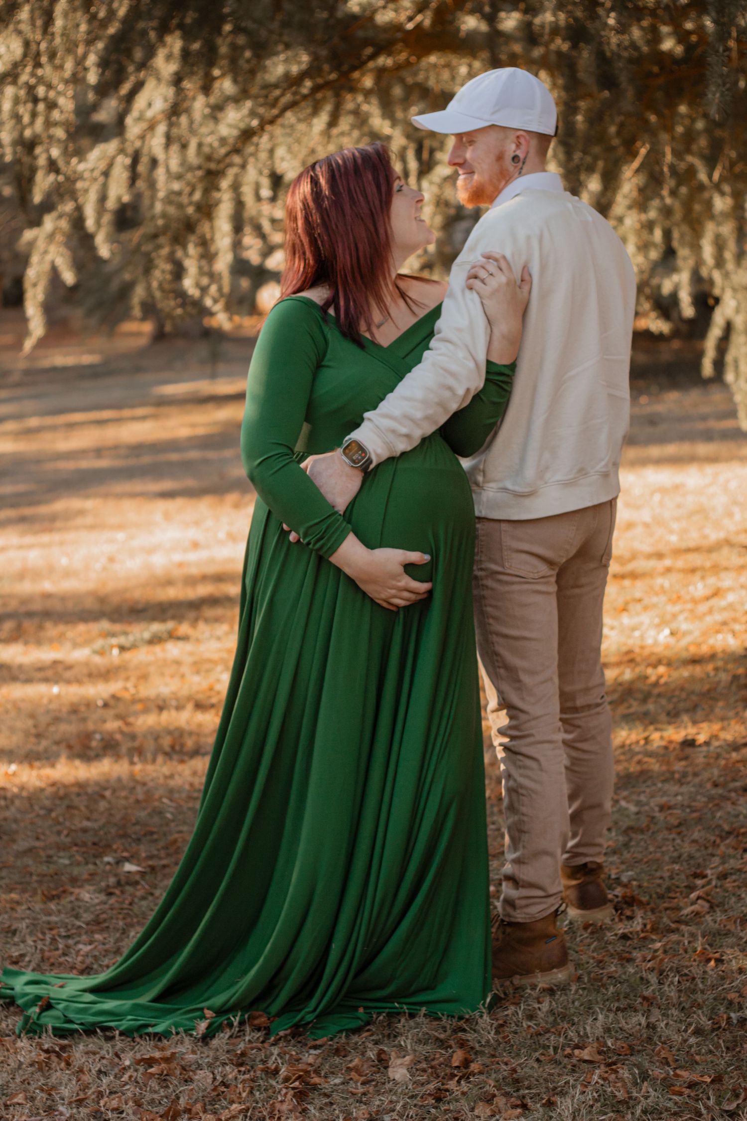 Maternity photo session in emerald green dress during golden hour.