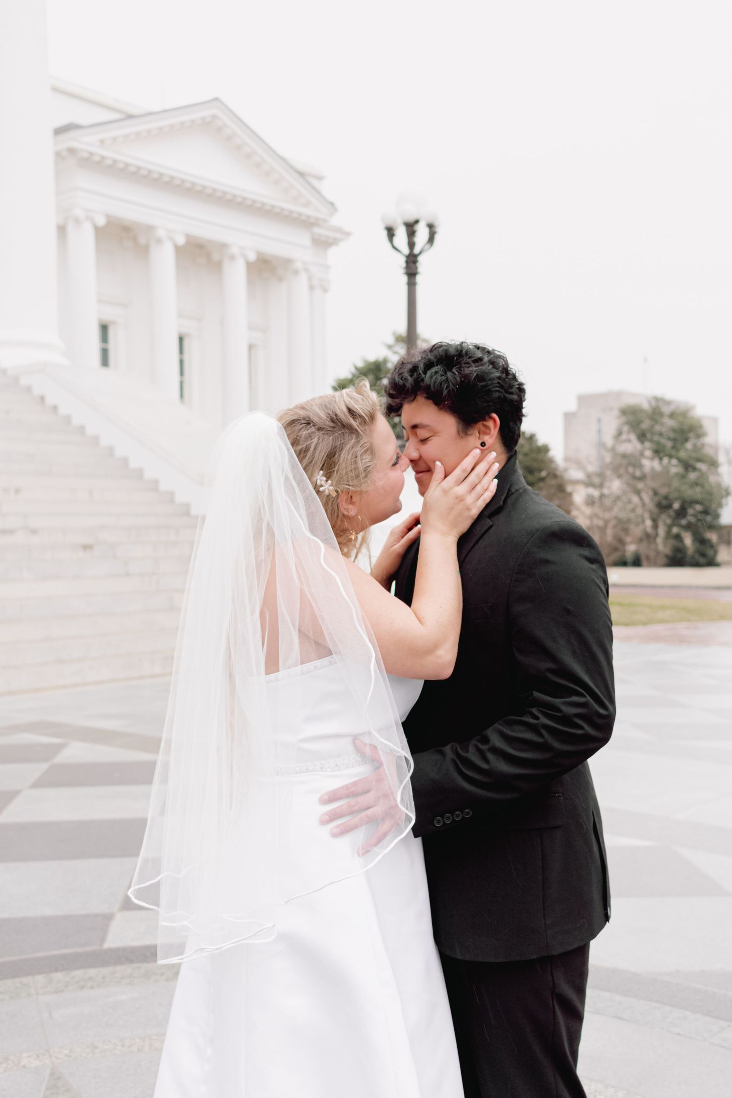 A romantic moment captured in front of a classical white columned building.