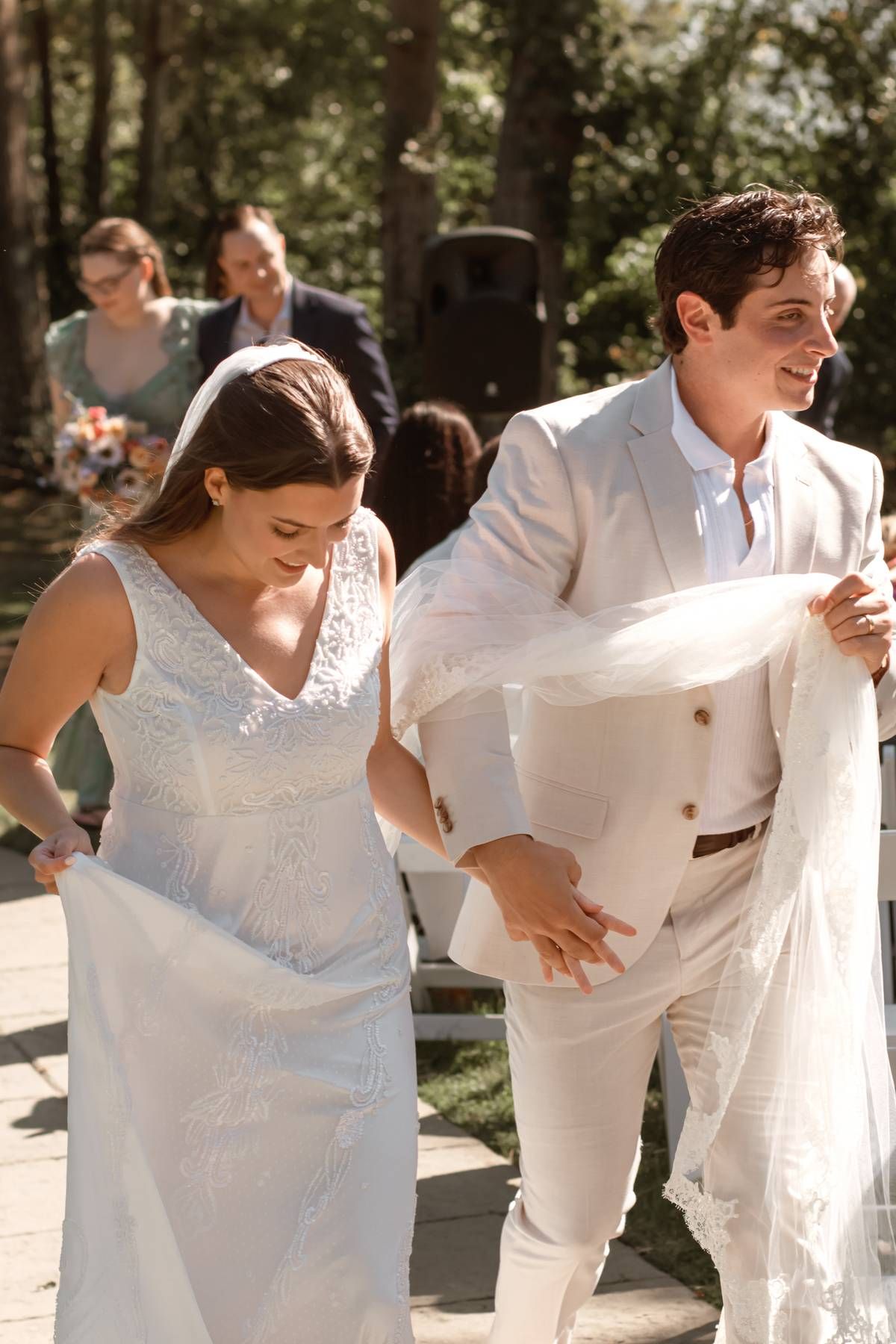 A candid moment of dancing and laughter during an outdoor wedding celebration.