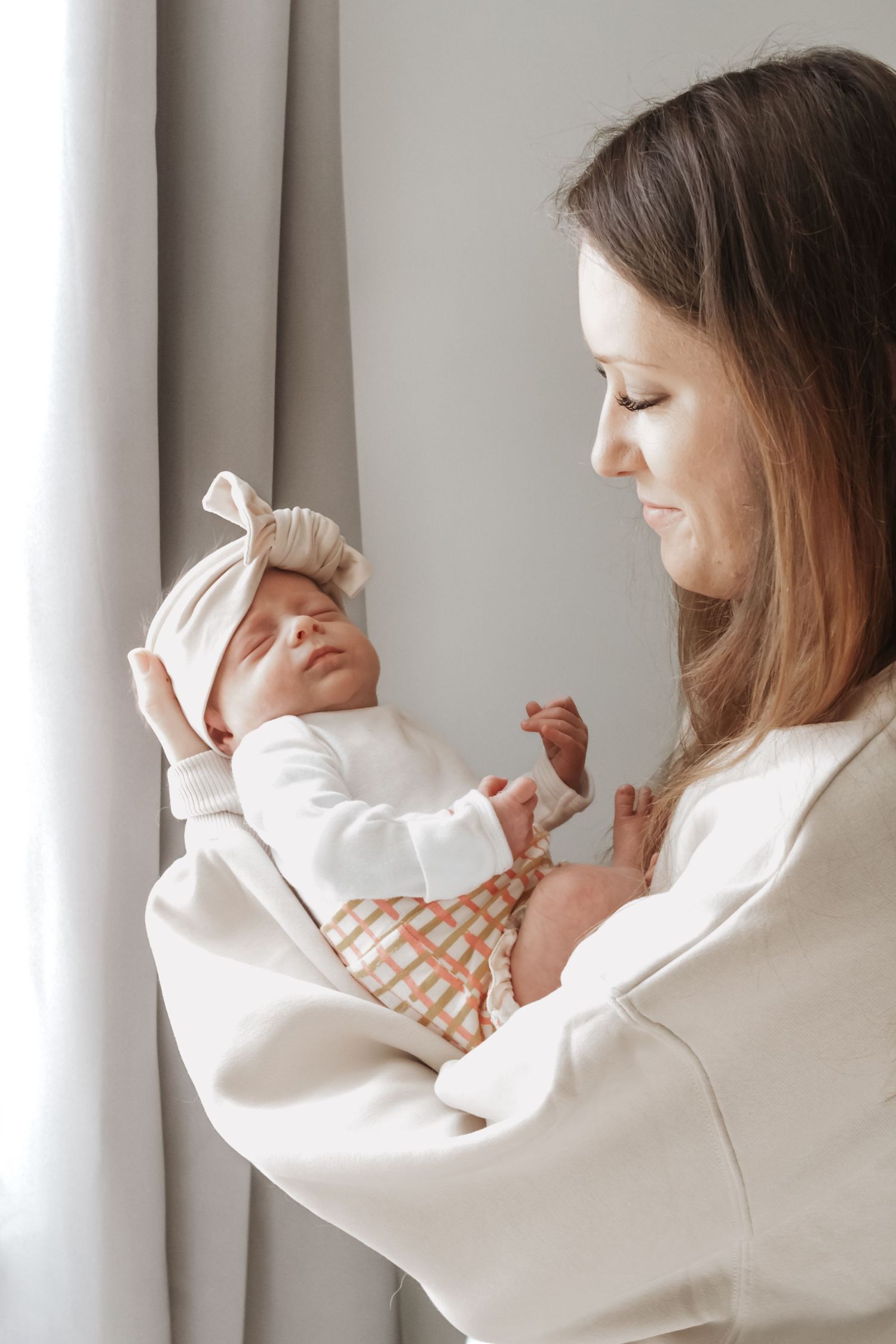 Mother in white sweater holding and playing with baby in series of tender moments.