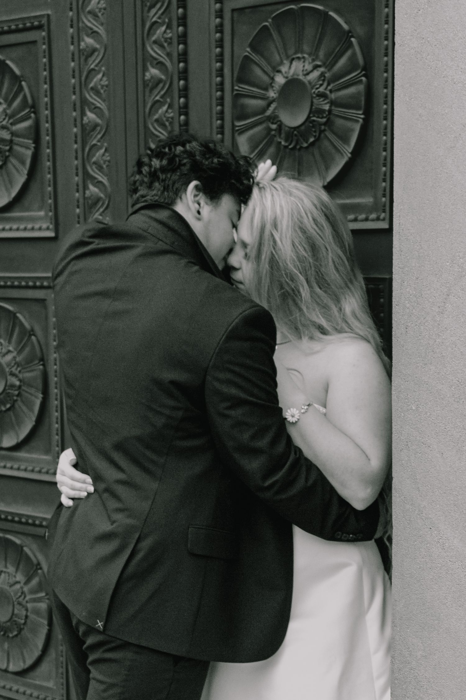 Black and white wedding photos show romantic poses against an ornate architectural backdrop.