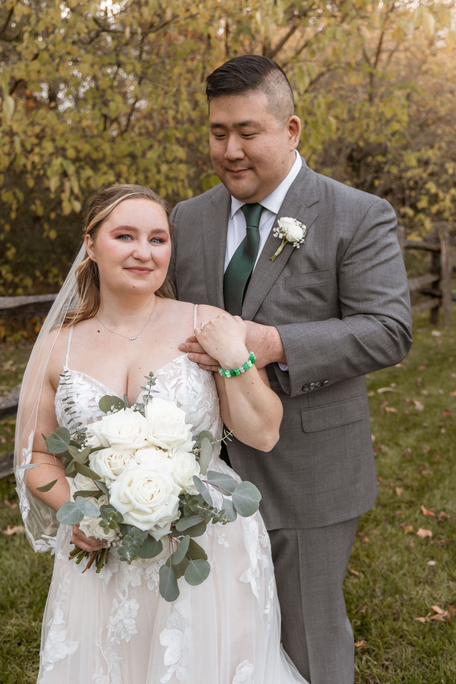 Bride in flowing white gown holds bouquet during outdoor autumn wedding photoshoot.