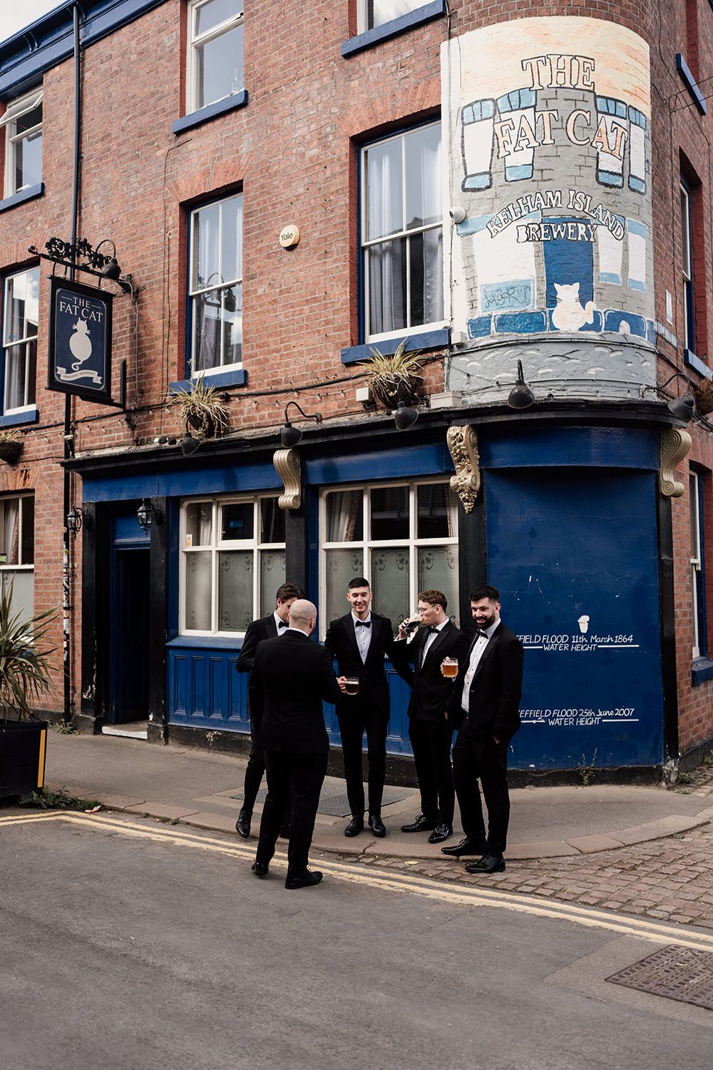 A series of photos showing groomsmen gathered outside a brick building with blue trim and storefronts.
