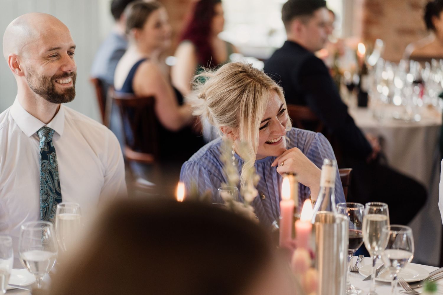 Candlelit dinner scene with guests enjoying conversation at an elegant reception.