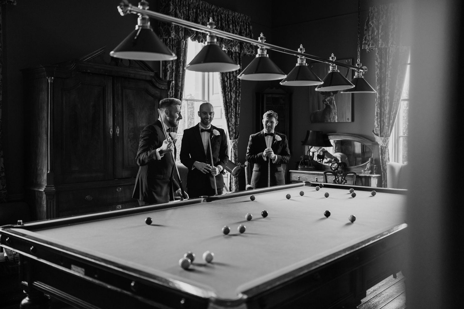 Black and white image of groomsmen playing pool at middleton lodge.