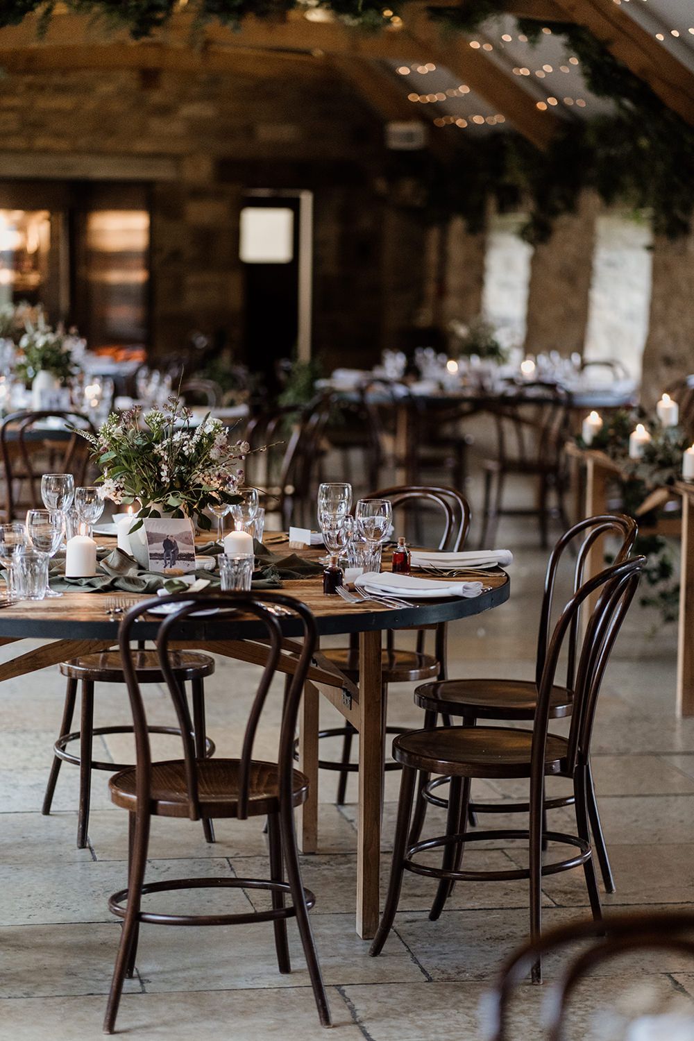 Brown wooden tables and chairs at Healey Barn in the reception room.