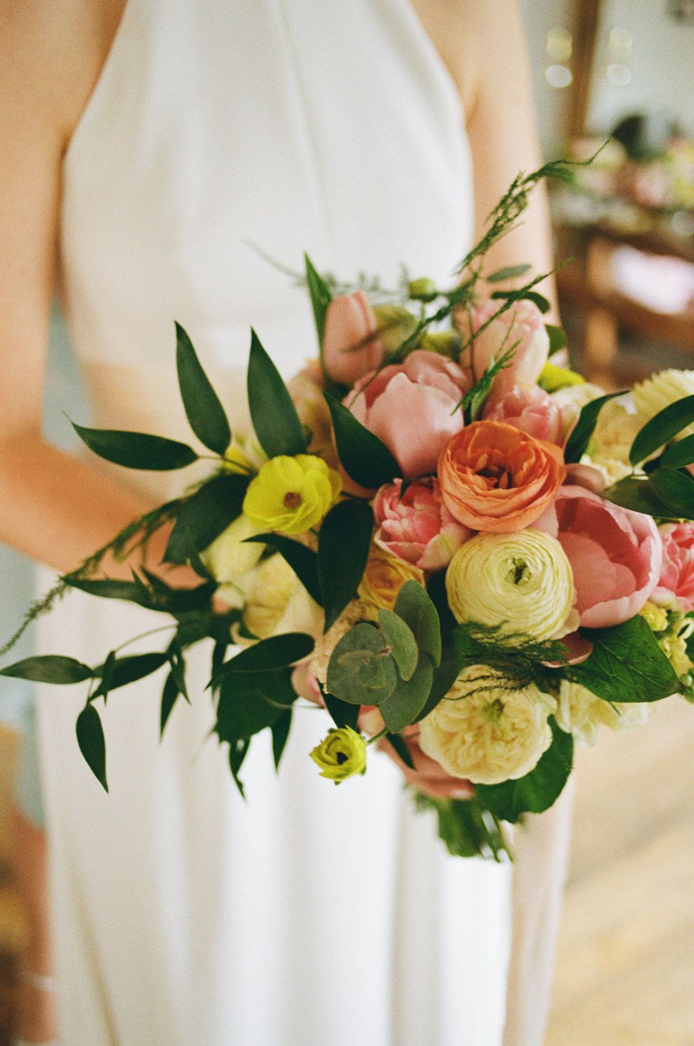 Bride holding her wedding bouquet full of spring wild flowers.