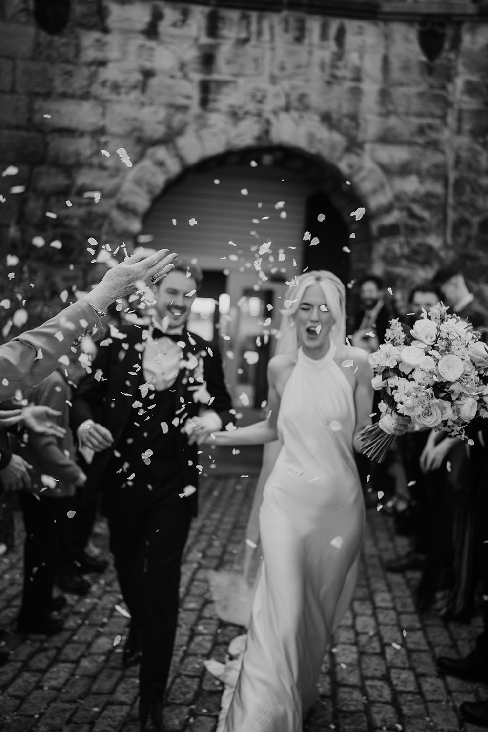 Wedding party confetti shot: Guests at The Secret Tower Newcastle captured by an editorial wedding photographer